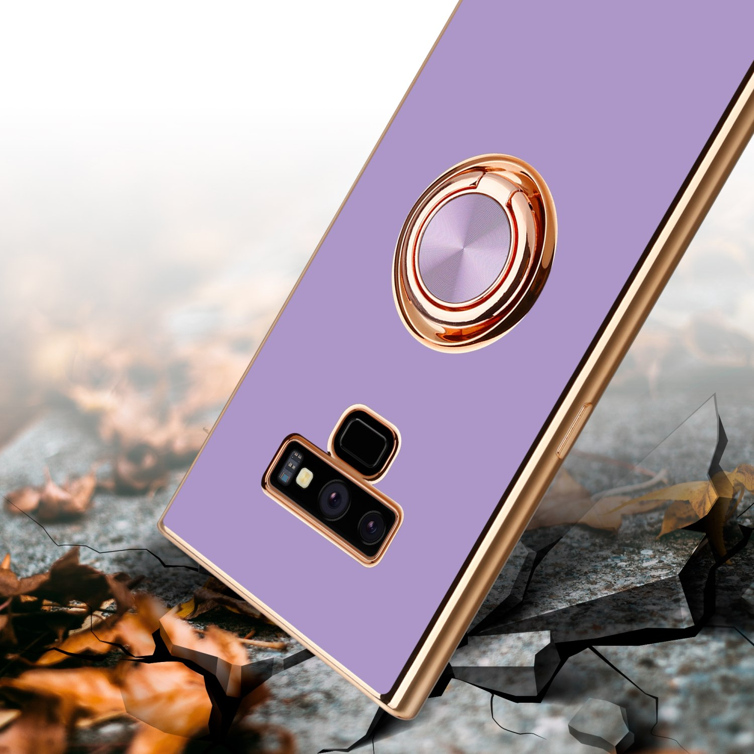 Custodia viola per telefono con bordo e anello dorati. Sfondo in pietra con crepe.
