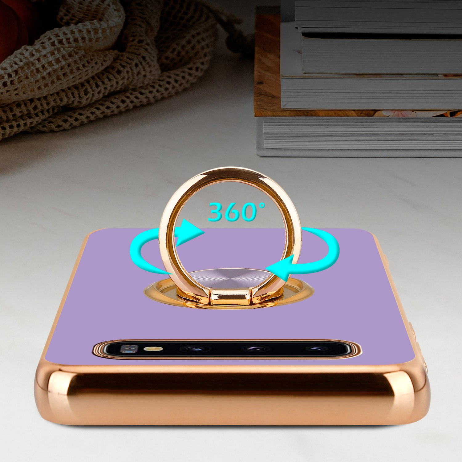 Ein Telefon mit lila Rückseite und einem goldenen Ringhalter mit 360°-Dre Pfeilsymbol.