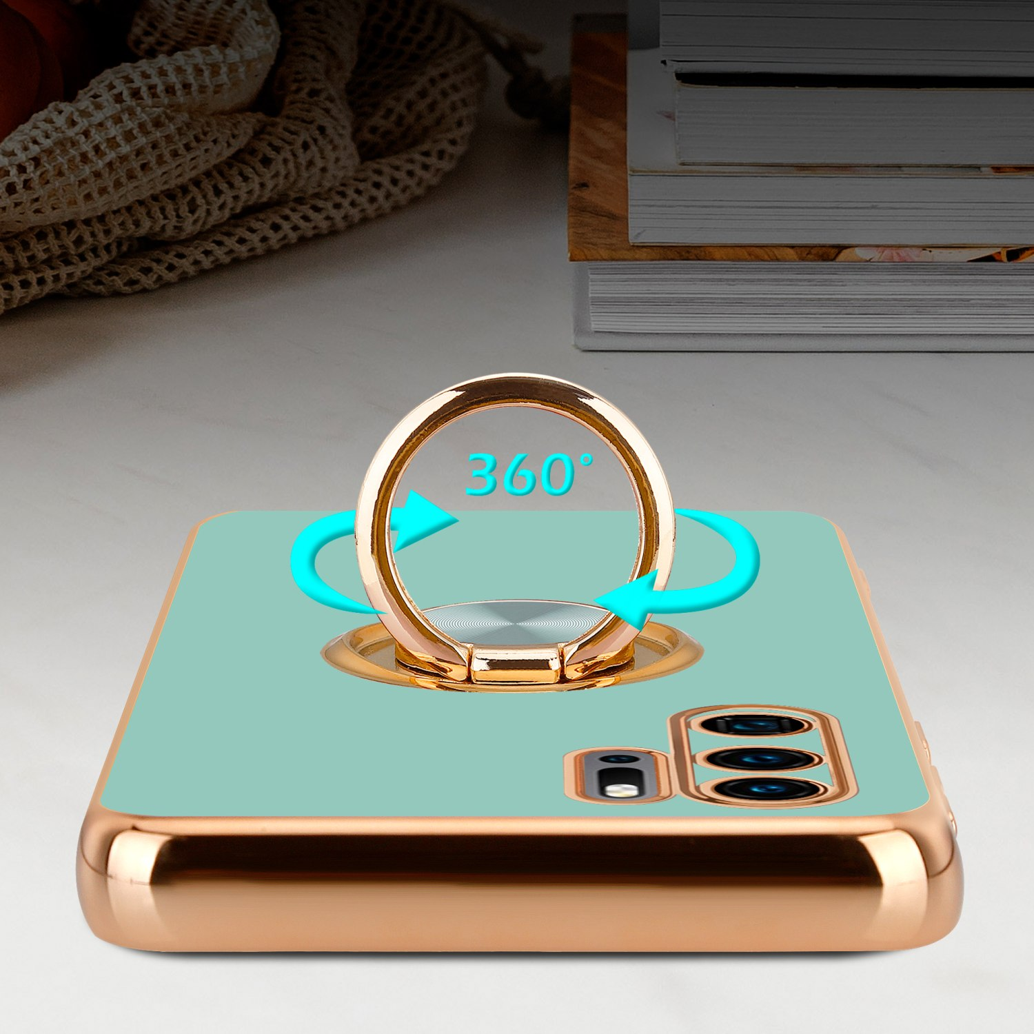 Eine Handyhülle mit Ringhalter, die 360° Drehung zeigt. Die Hülle ist türkis mit Goldrahmen.