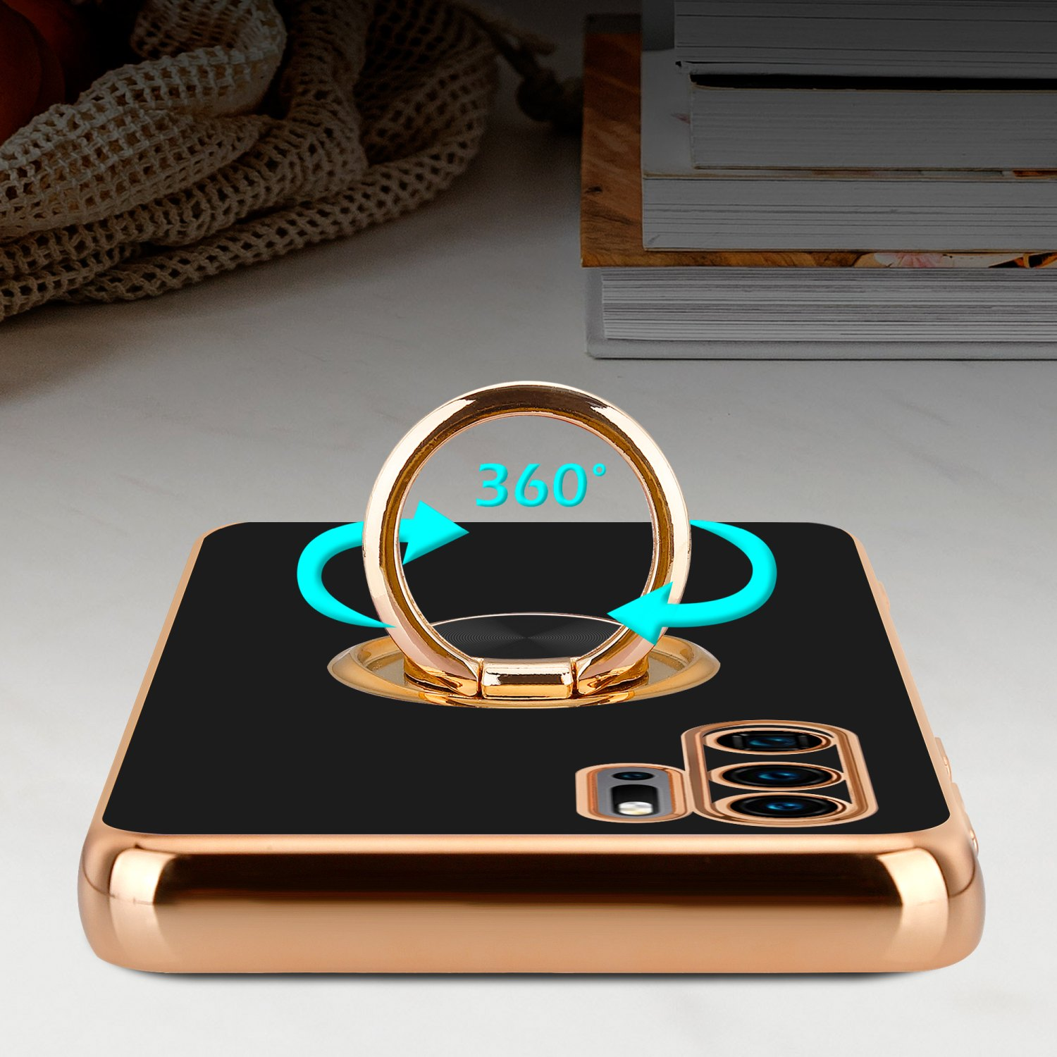 Coque de téléphone noire avec support de bague doré affichant des flèches de rotation à 360°. Fond blanc.