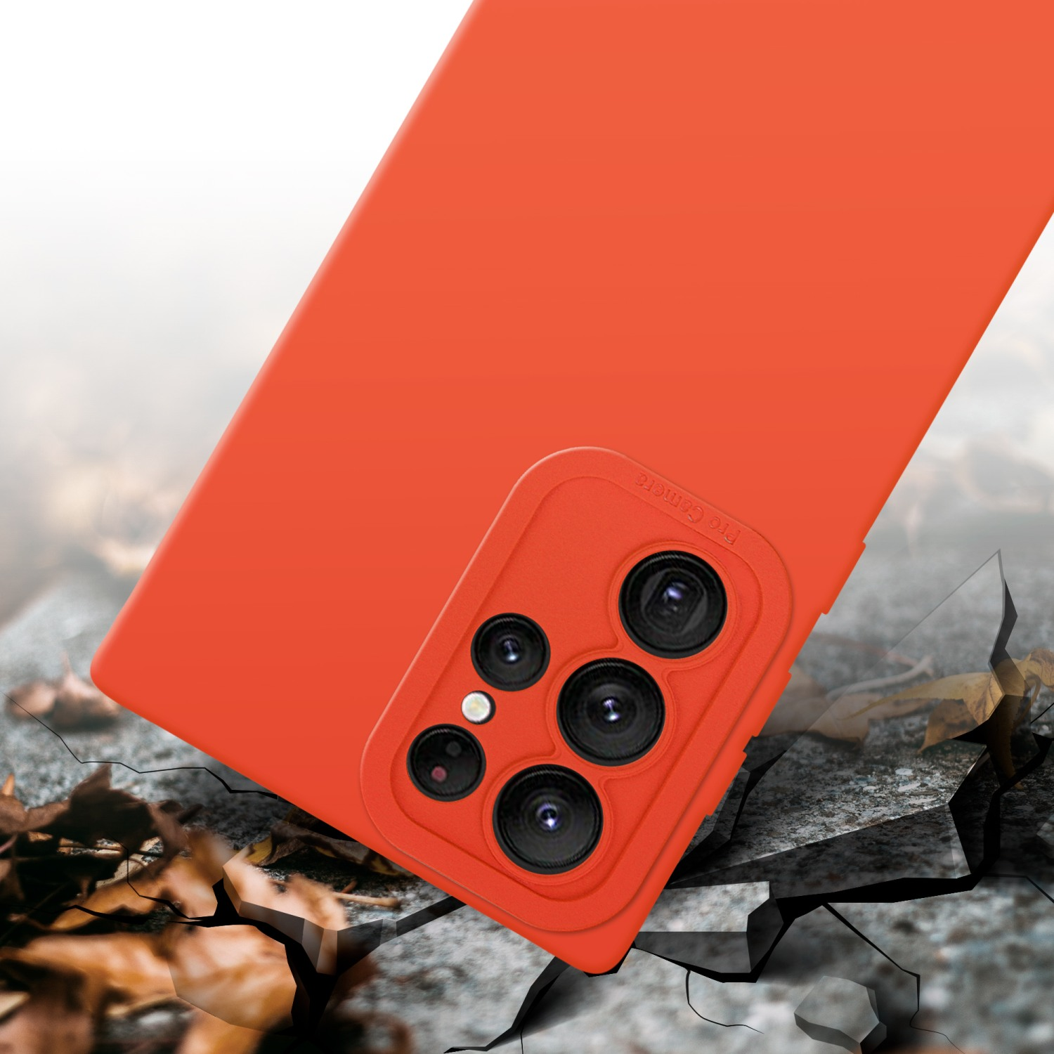 Coque de téléphone orange posée sur un sol cassé. La coque a une bosse pour la caméra.