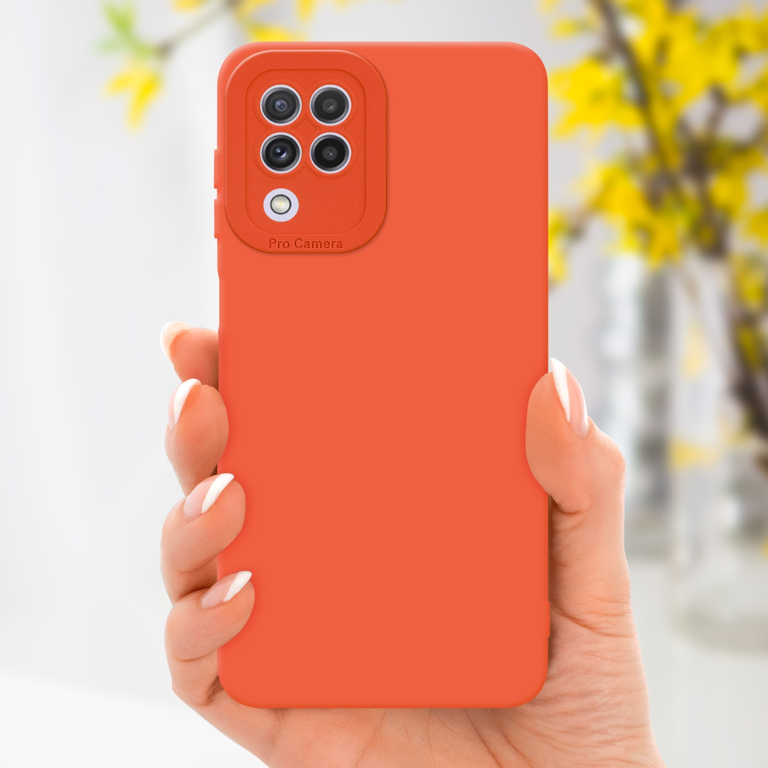 Mano che tiene custodia arancione con 'Pro Camera'. Fiori gialli sfocati sullo sfondo.