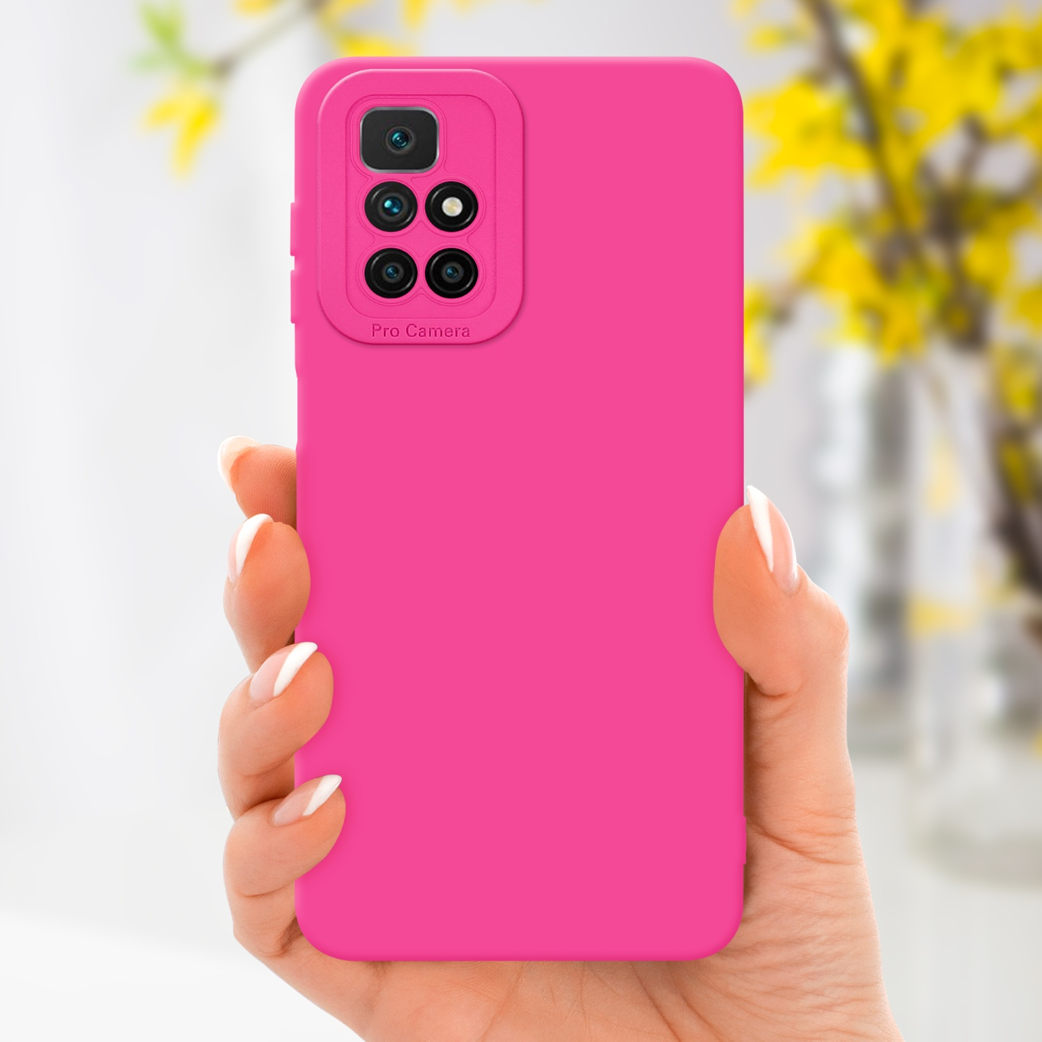 Una mano che tiene una custodia rosa per telefono con ritaglio per la fotocamera. Fiori gialli sullo sfondo.