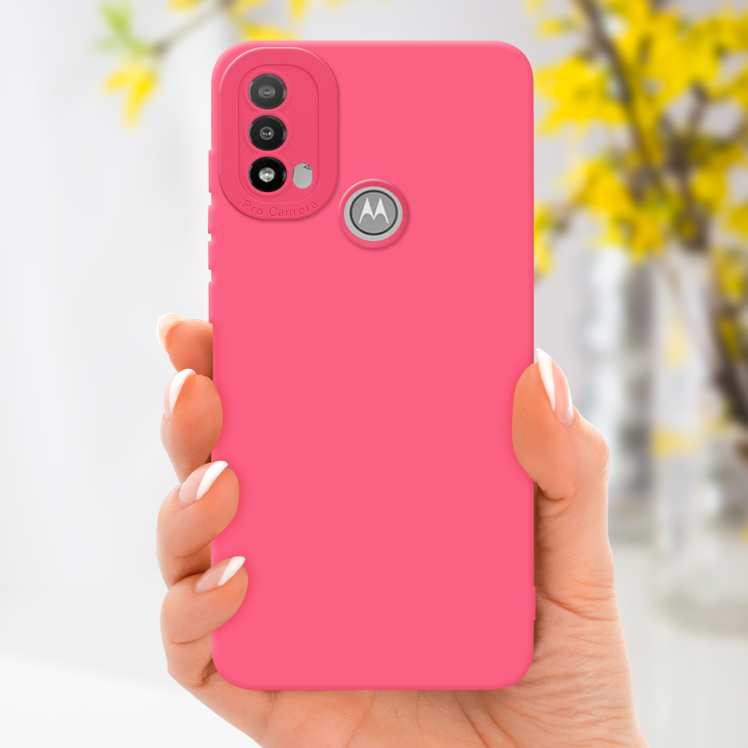 Una custodia per telefono rosa con un bordo della fotocamera rialzato, tenuta in mano con unghie bianche.