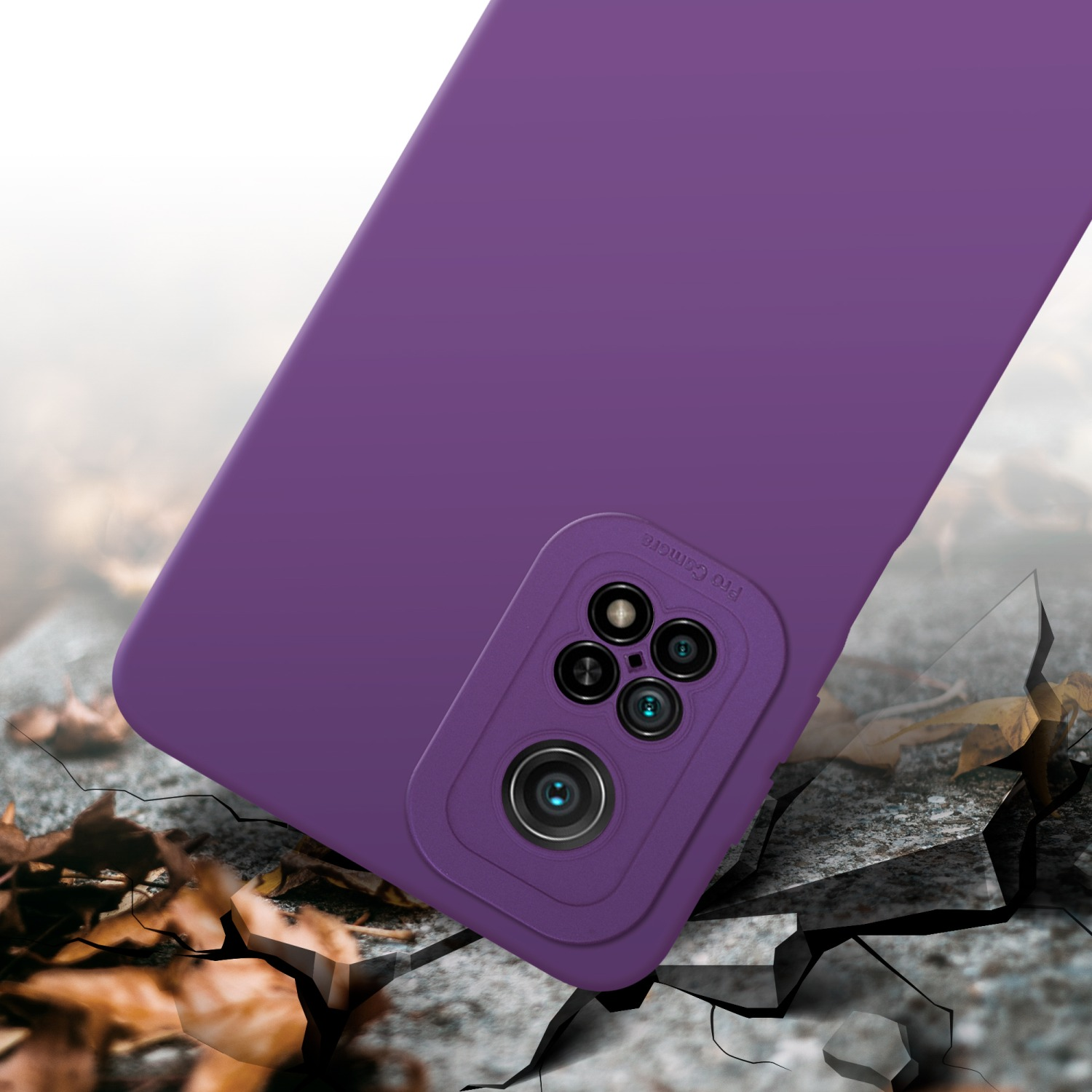Coque de téléphone violette avec zone caméra. Surface fissurée avec feuilles sèches en arrière-plan.