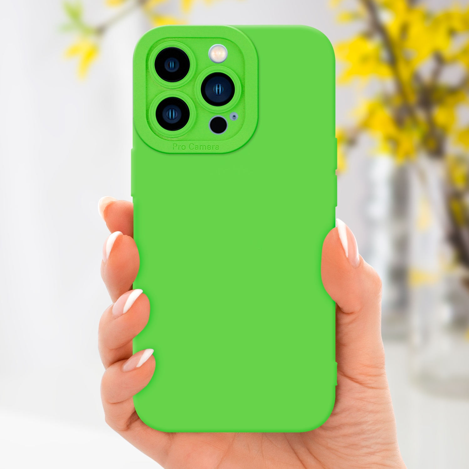 Una mano che tiene una custodia verde per telefono. Fiori gialli sullo sfondo.