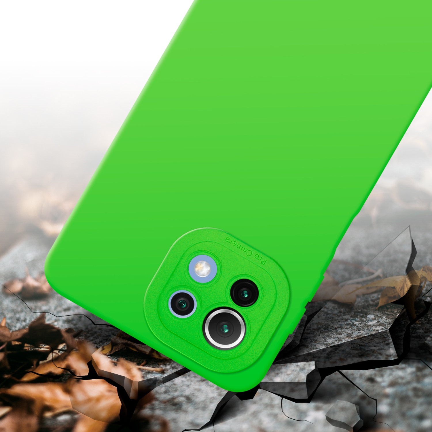 Custodia per telefono verde con fotocamera su terreno crepato. Foglie marroni sullo sfondo.