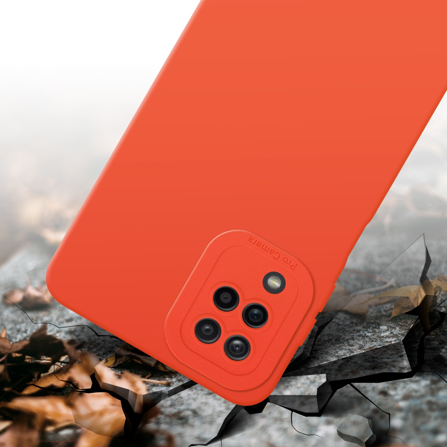 Una custodia arancione per telefono con ritagli per la fotocamera su una superficie incrinata. Foglie sparse.