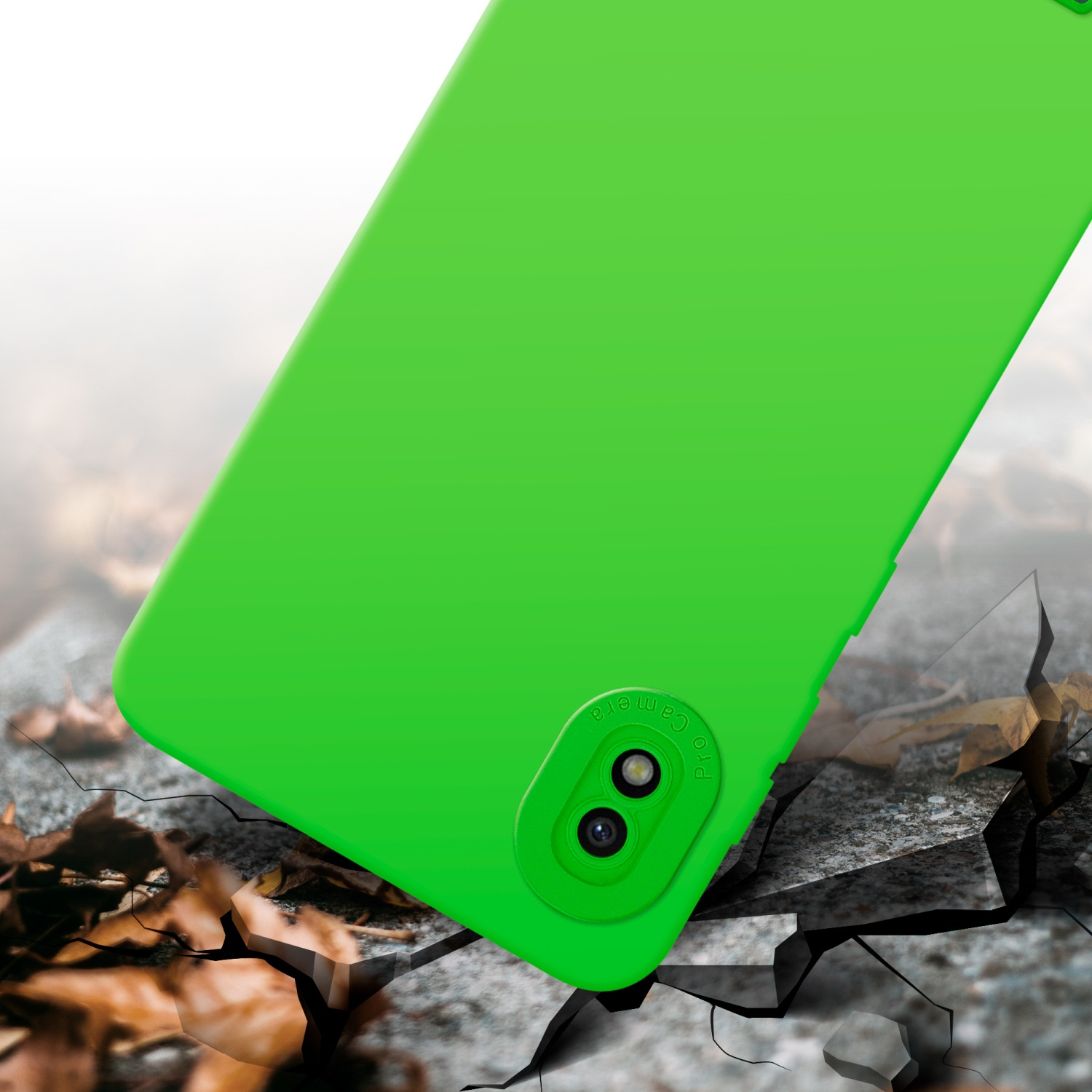 Custodia per telefono verde su una superficie incrinata. La custodia ha un rialzo della fotocamera. Lo sfondo è sfocato.
