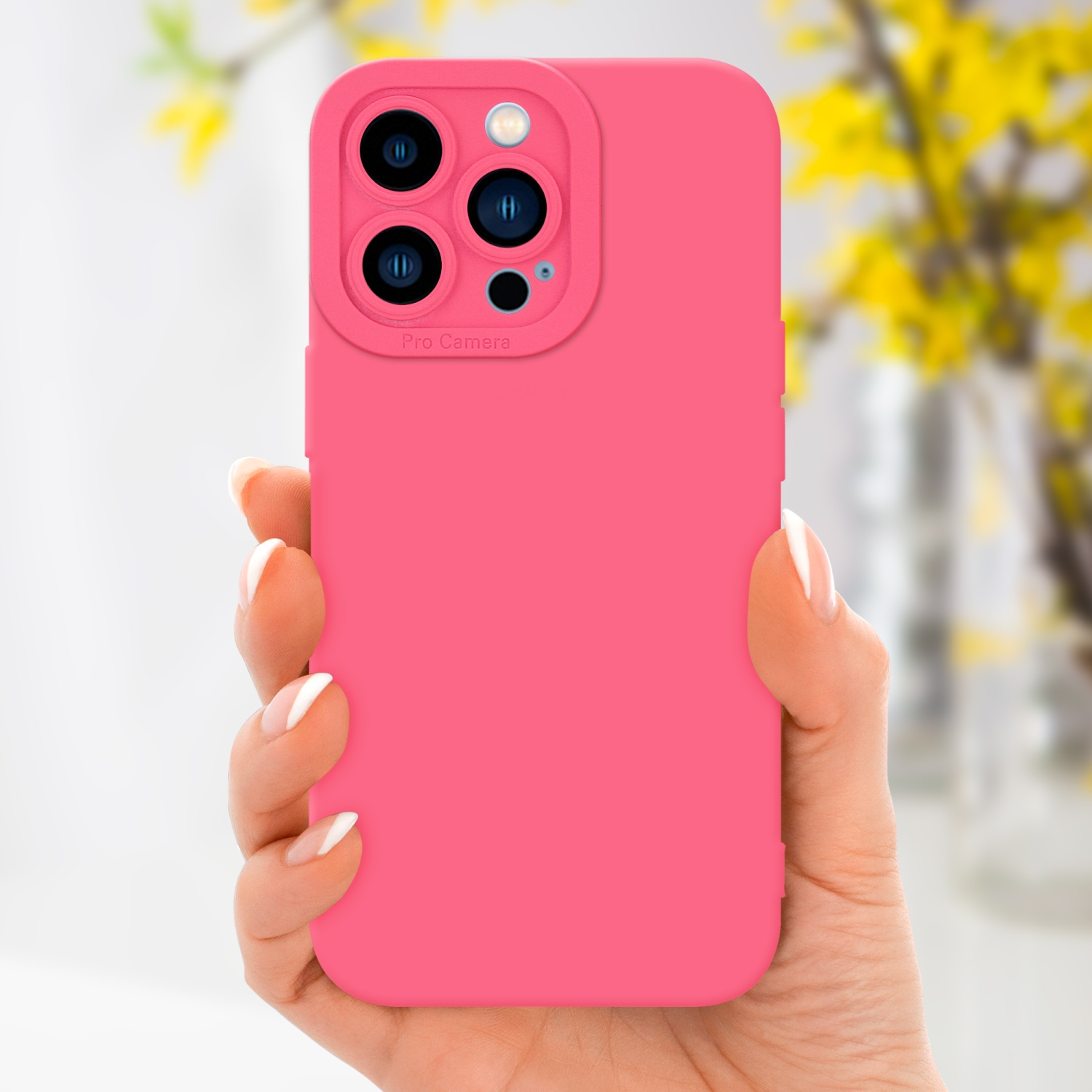 Una mano che tiene una custodia rosa con una fotocamera, con uno sfondo di fiori gialli.