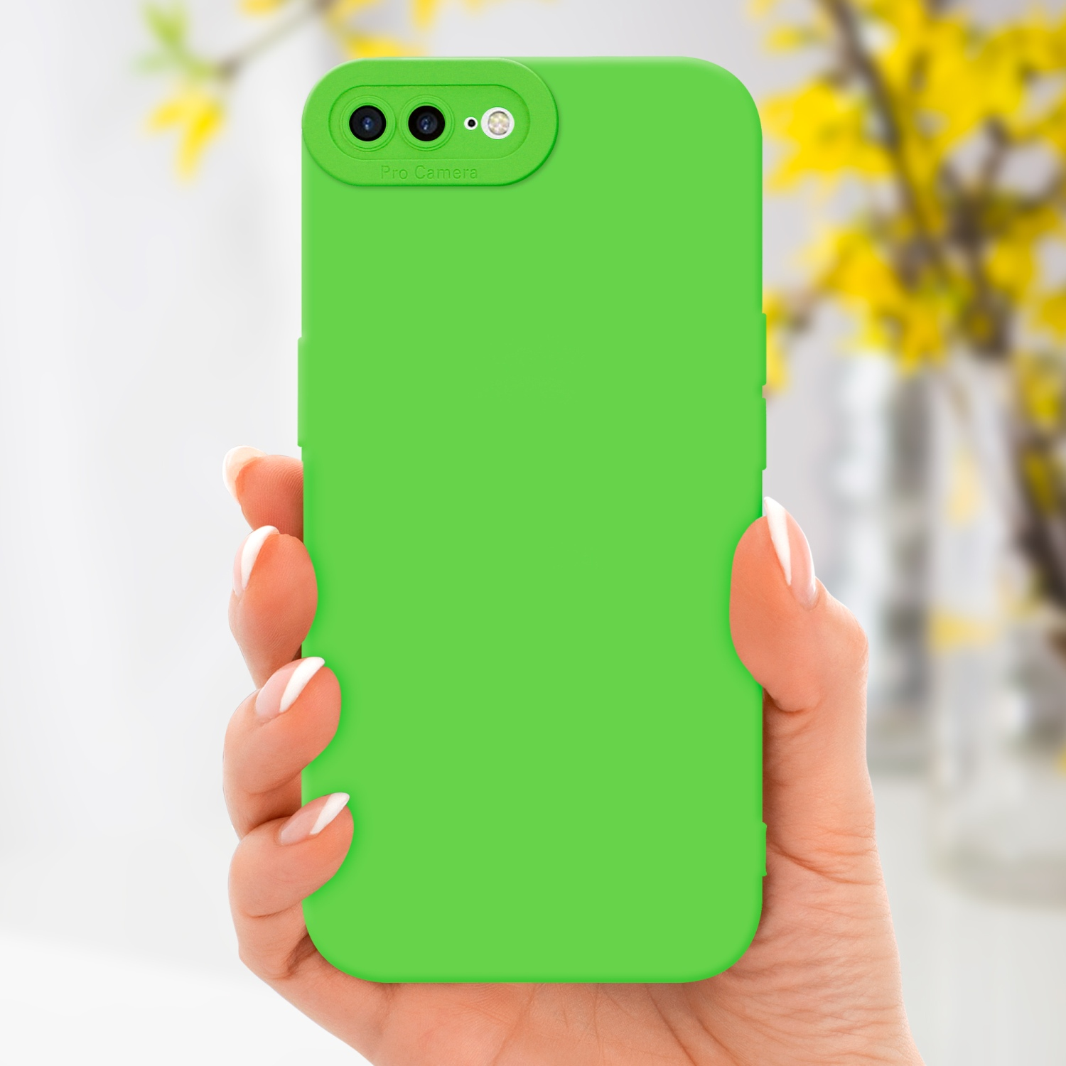 Una custodia per telefono verde tenuta in mano, con sfondo sfocato di fiori gialli.