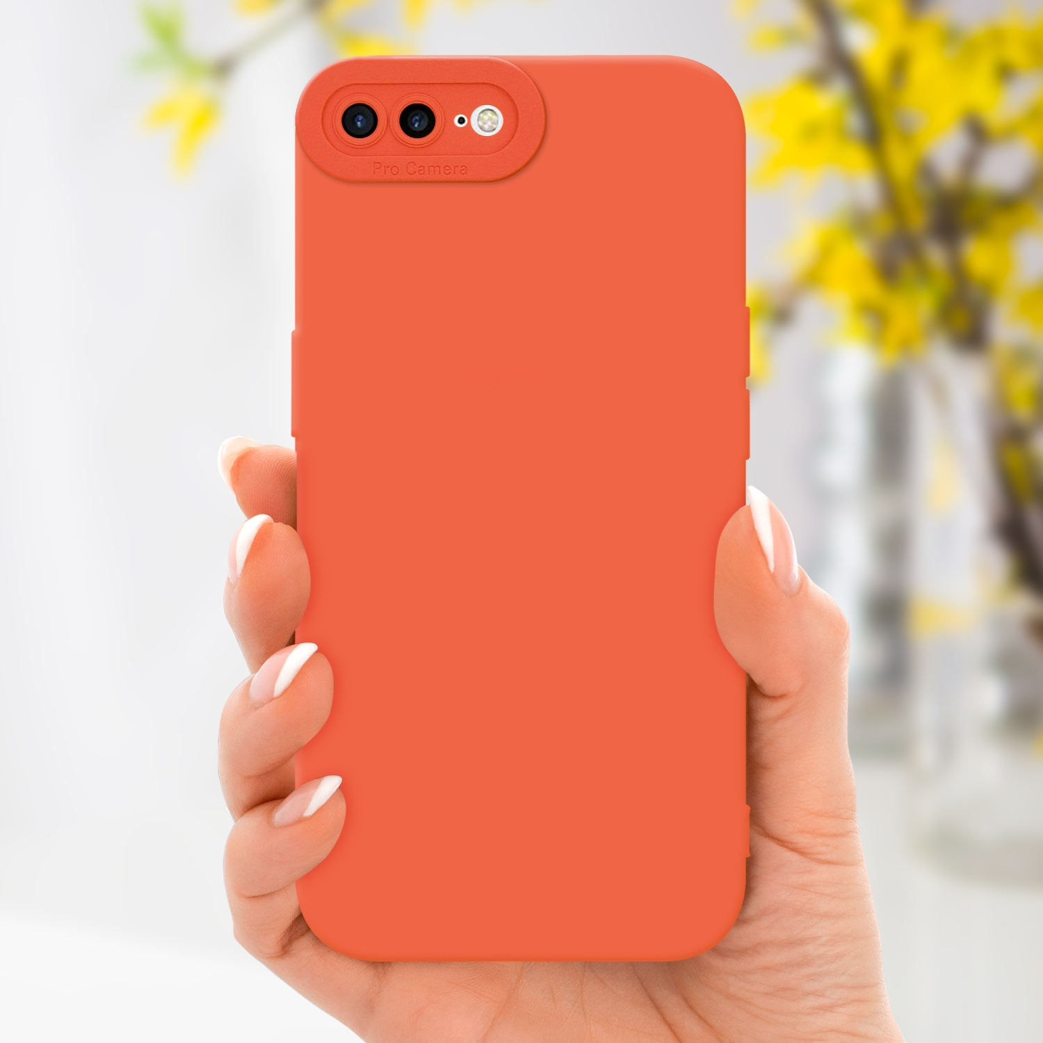 Una mano che tiene una custodia per telefono arancione. Fiori gialli sono visibili sullo sfondo.