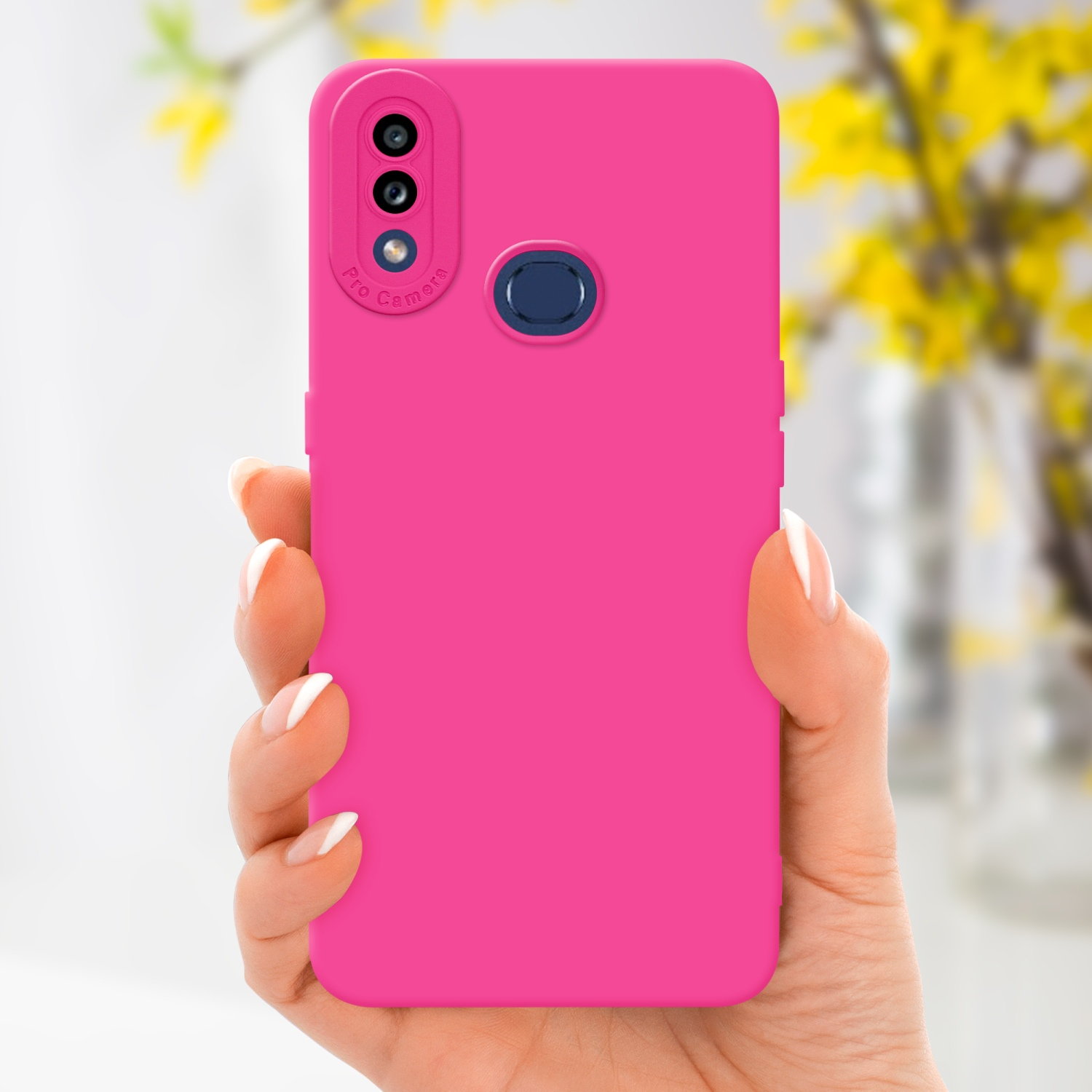 Mano che tiene una custodia rosa. Fiori gialli sfocati sullo sfondo.