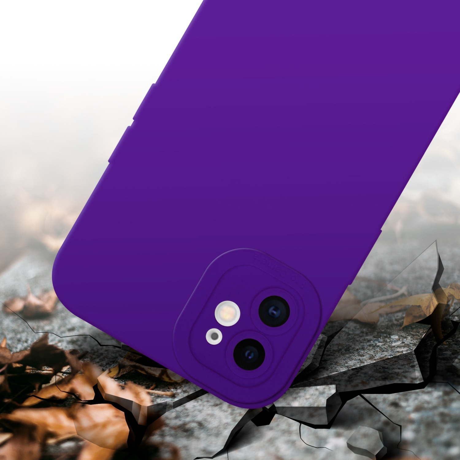 Custodia viola su cemento screpolato. Custodia vicino alle foglie. Obiettivo della fotocamera visibile.