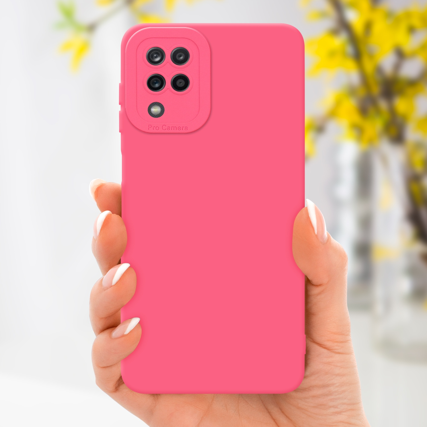 Mano che tiene una custodia rosa per telefono con più lenti della fotocamera, con fiori gialli sullo sfondo.