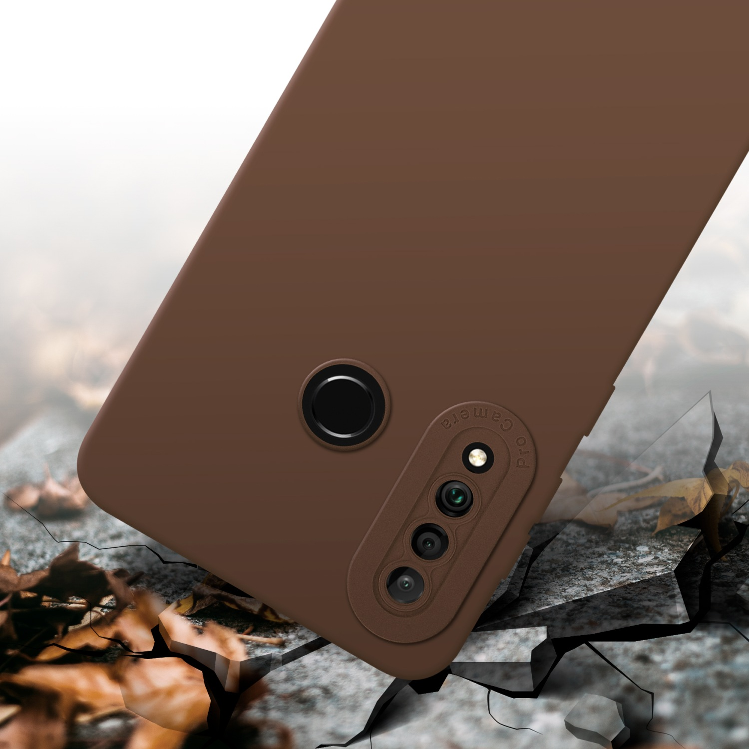 Custodia marrone con dettagli fotocamera neri, su superficie crepata con foglie autunnali.