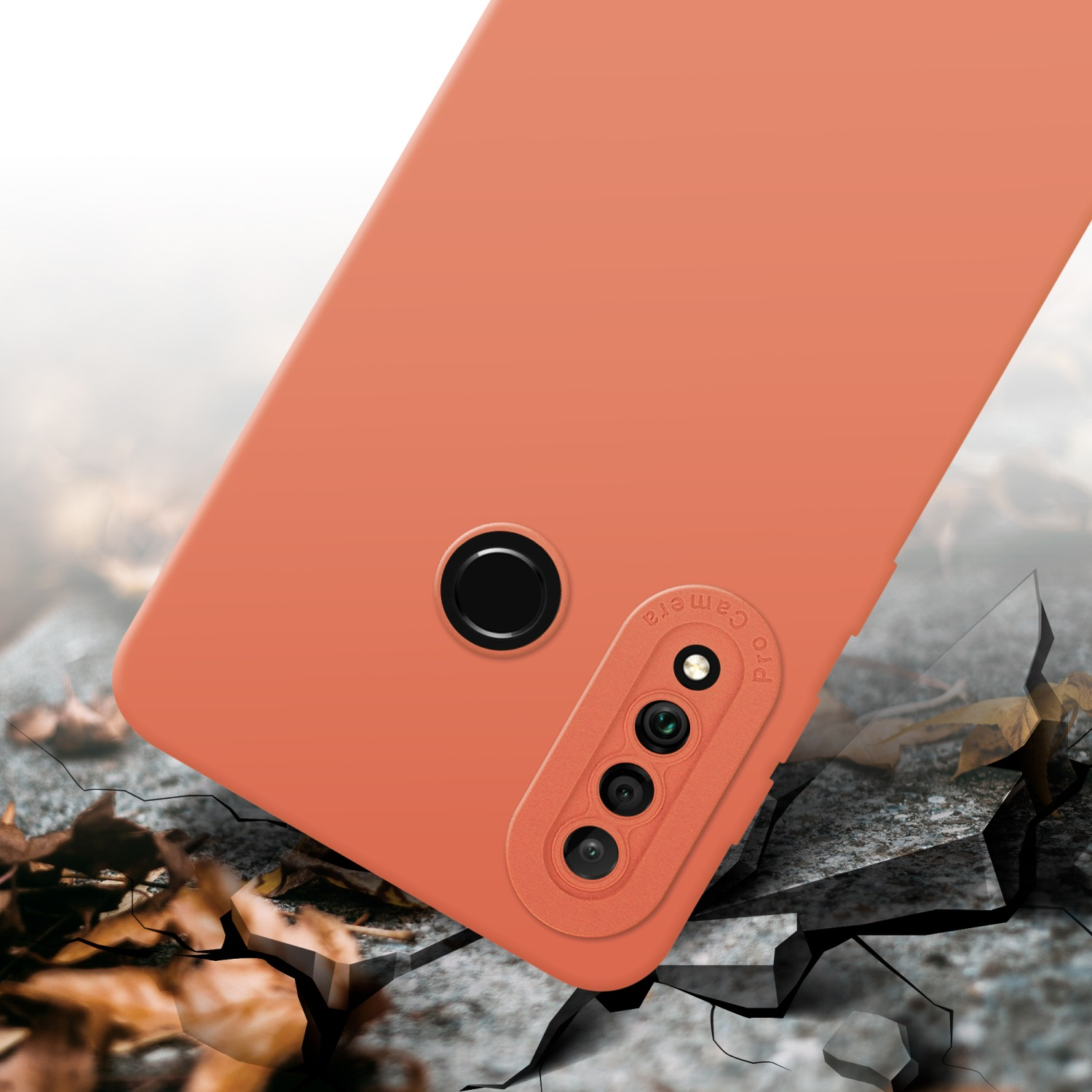 Custodia arancione per telefono con fori per fotocamera. Primo piano, con terreno crepato.