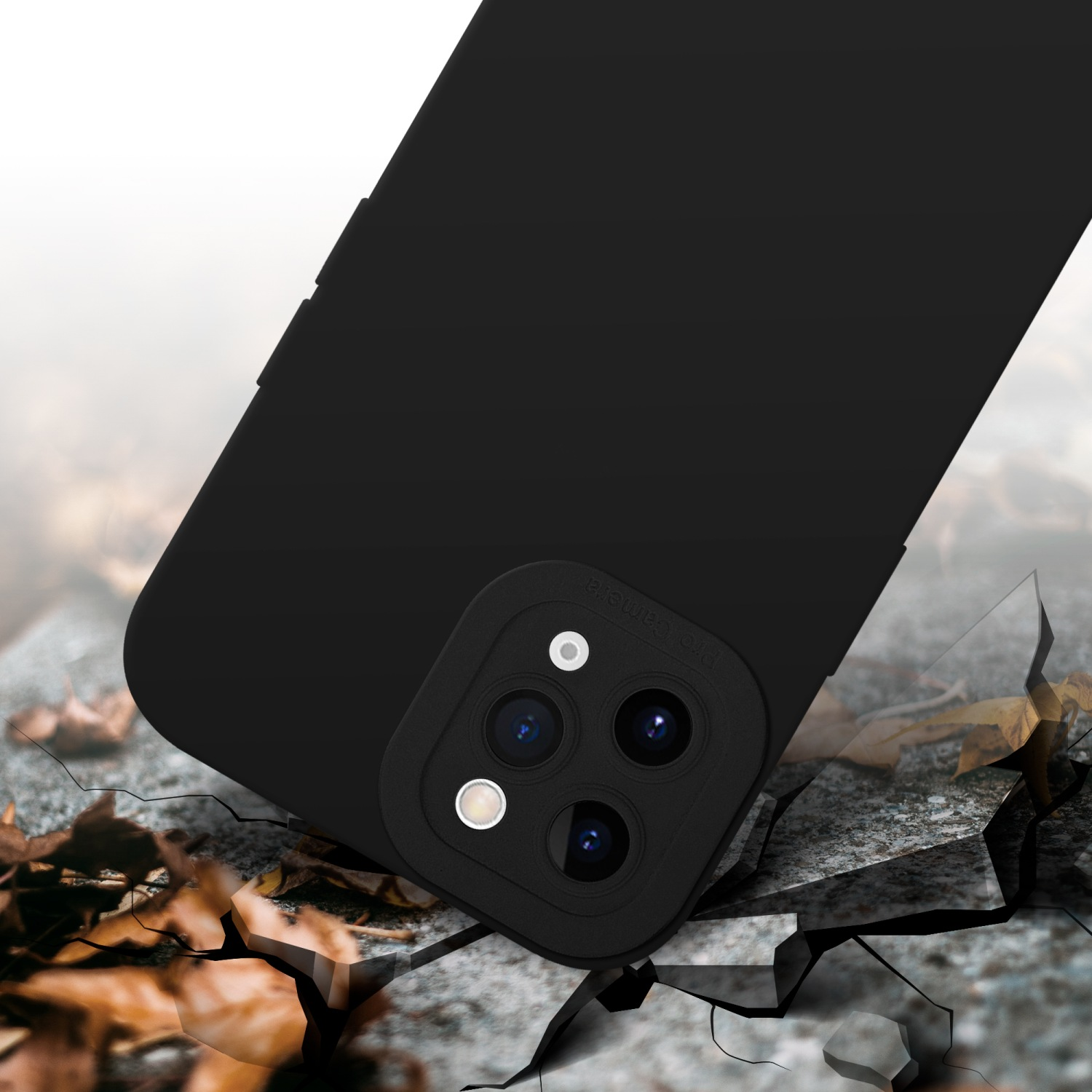 Custodia nera per telefono su superficie incrinata. Lo sfondo mostra il terreno e foglie.