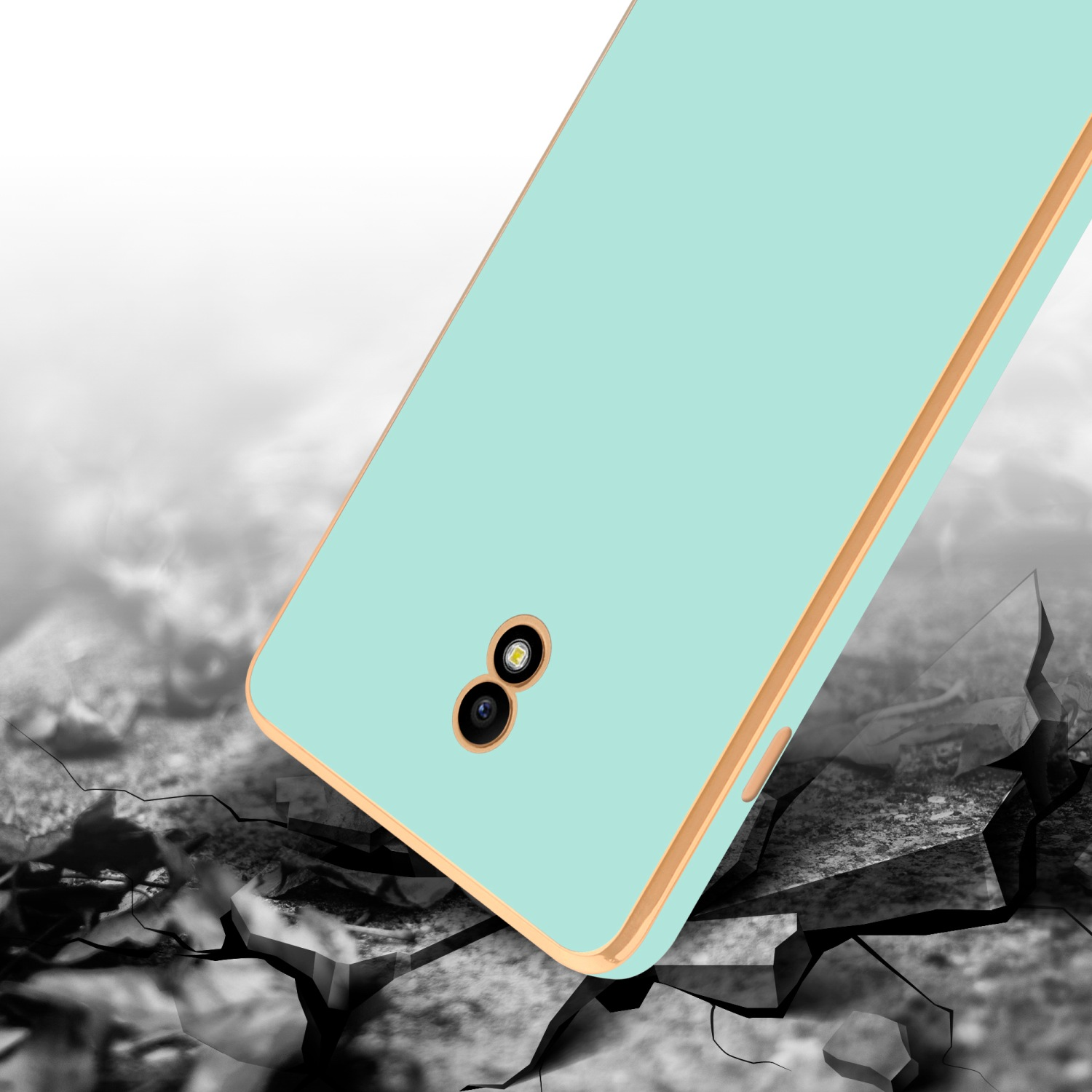 Blaue Handyhülle mit Goldbesatz auf zerbrochenem Boden. Telefon hat zwei Kameras.