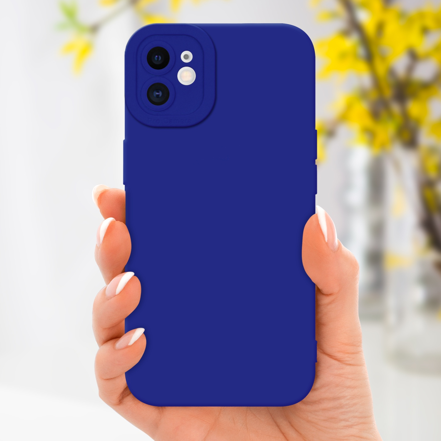 Una mano che tiene un telefono blu con custodia blu. Fiori gialli sullo sfondo sfocato.