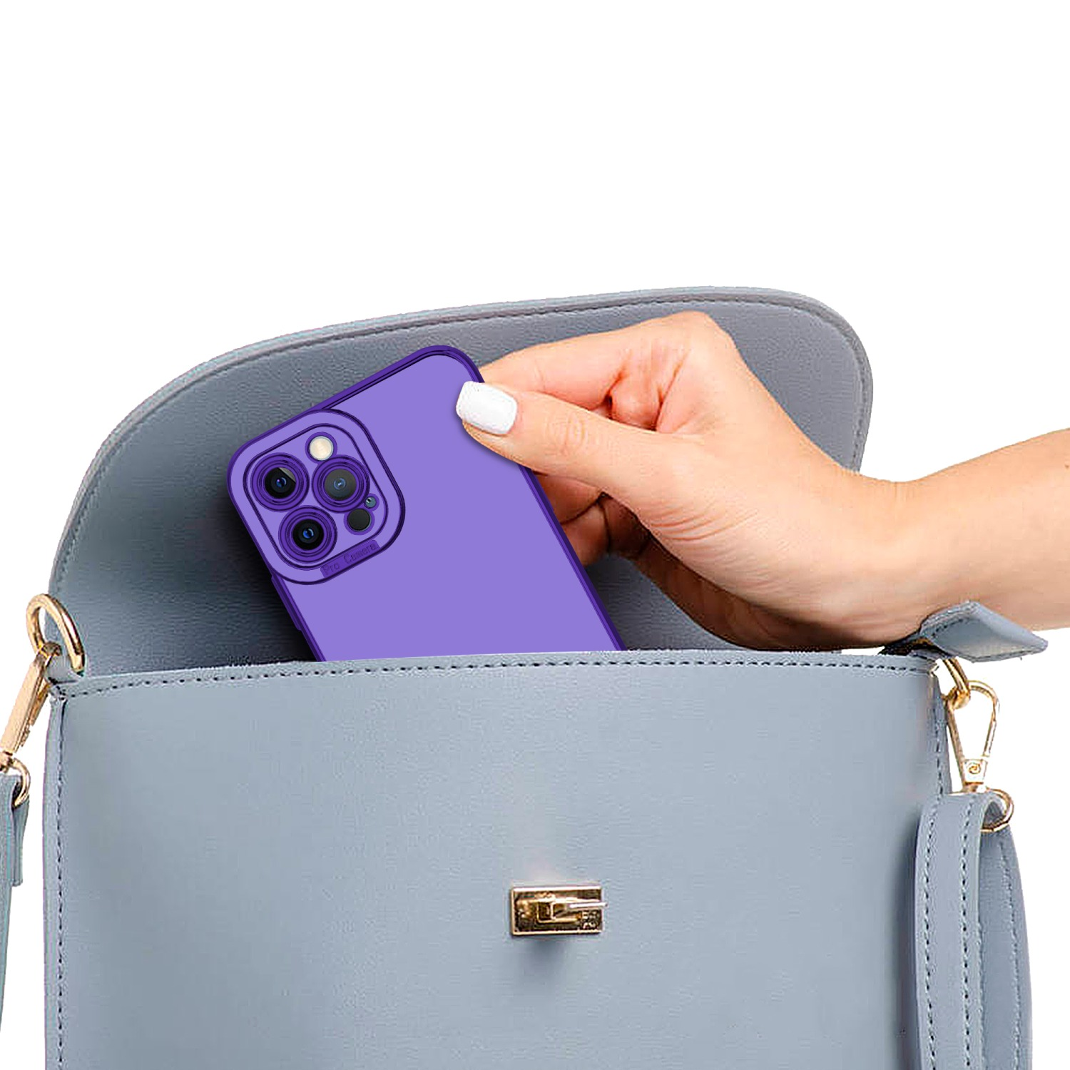 Eine Hand hält ein lila Telefon mit Hülle in einer blauen Handtasche. Weißer Hintergrund.