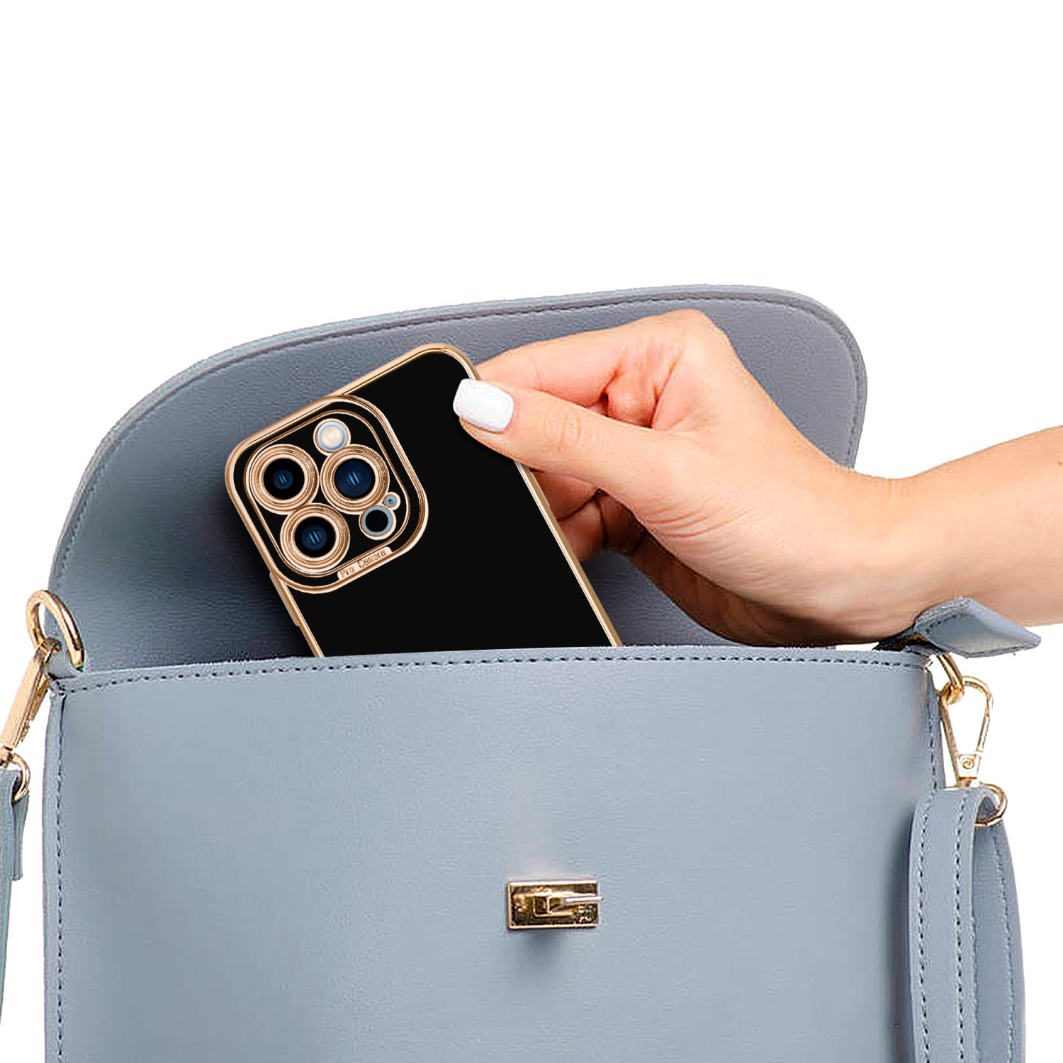 Eine Hand legt ein Telefon in eine hellblaue Handtasche. Das Telefon hat einen schwarzen Bildschirm und ein goldenes Gehäuse.
