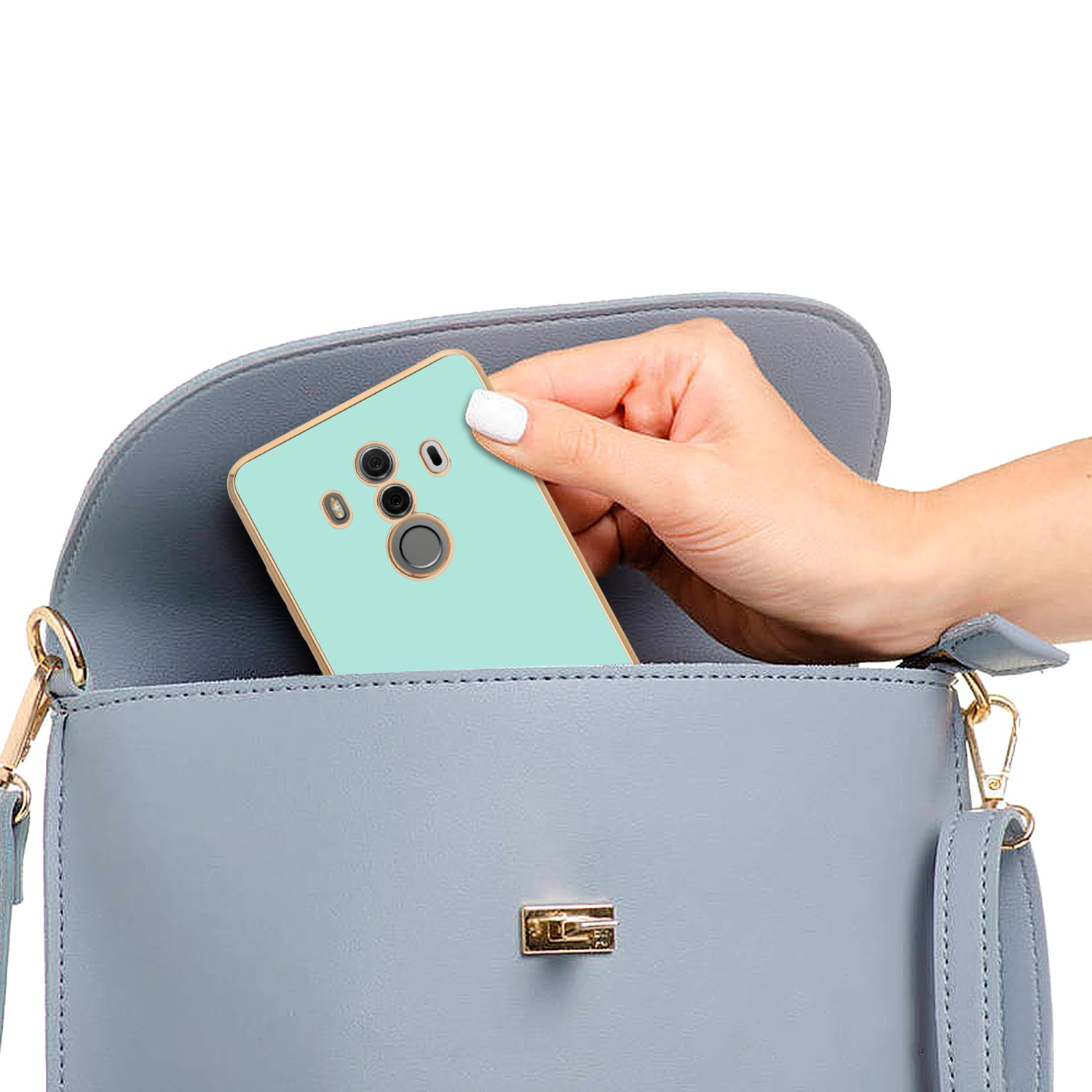 Hand hält ein türkisfarbenes Telefon in einer blauen Handtasche.