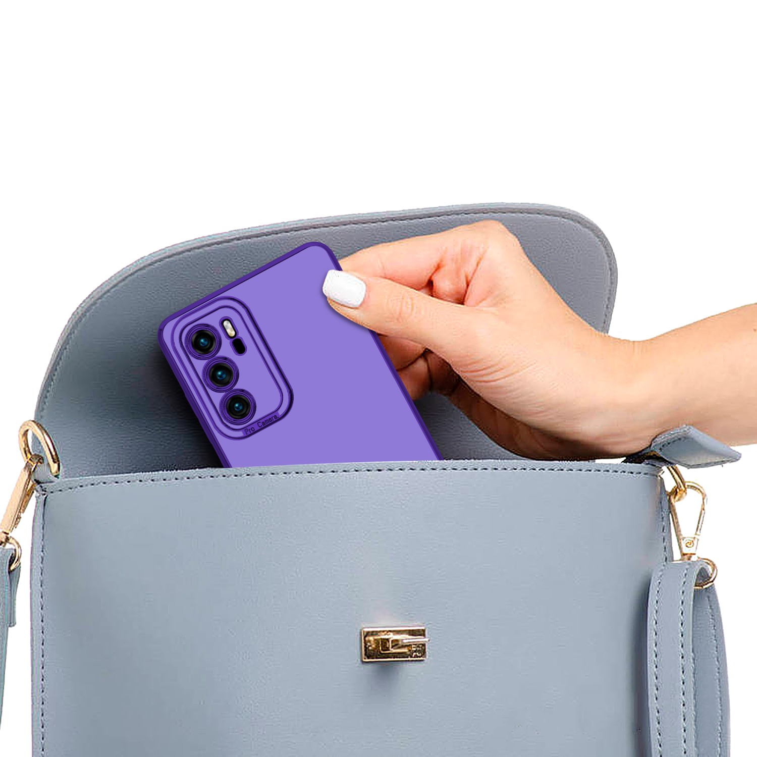 Hand legt lila Telefon in graue Handtasche. Das Telefon hat einen goldenen Rahmen.