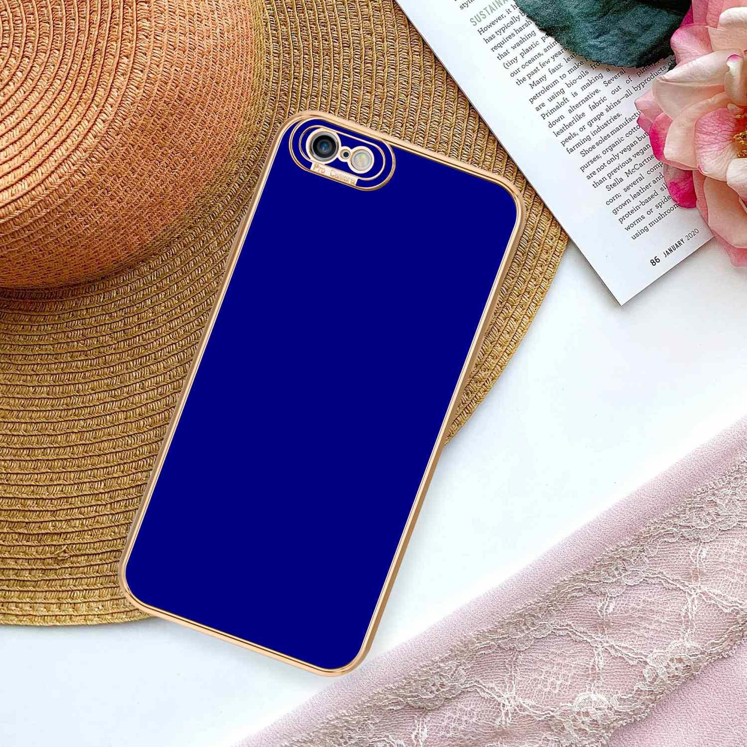 Blaue Handyhülle auf Magazin. Rosa Band im Hintergrund.