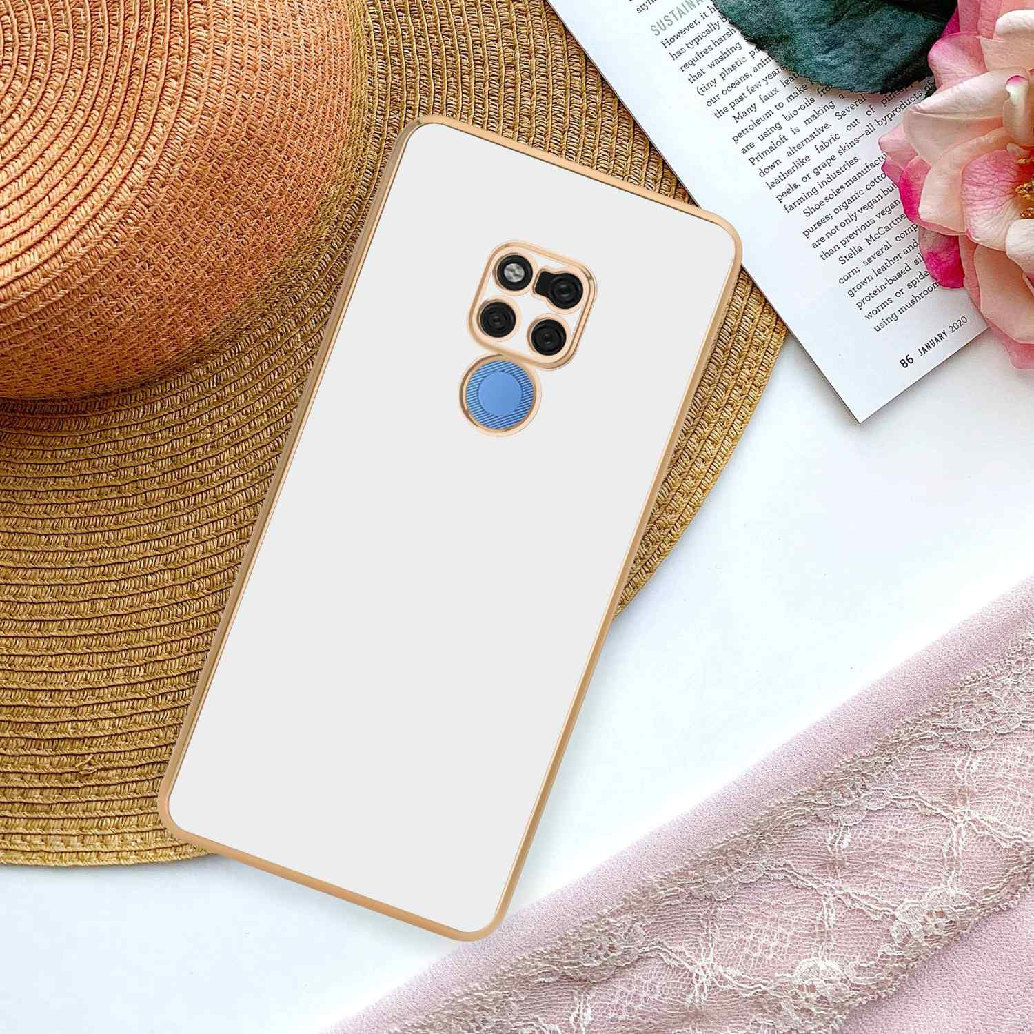 Weißes Telefon mit goldenem Rahmen, auf Papier und Blumen.