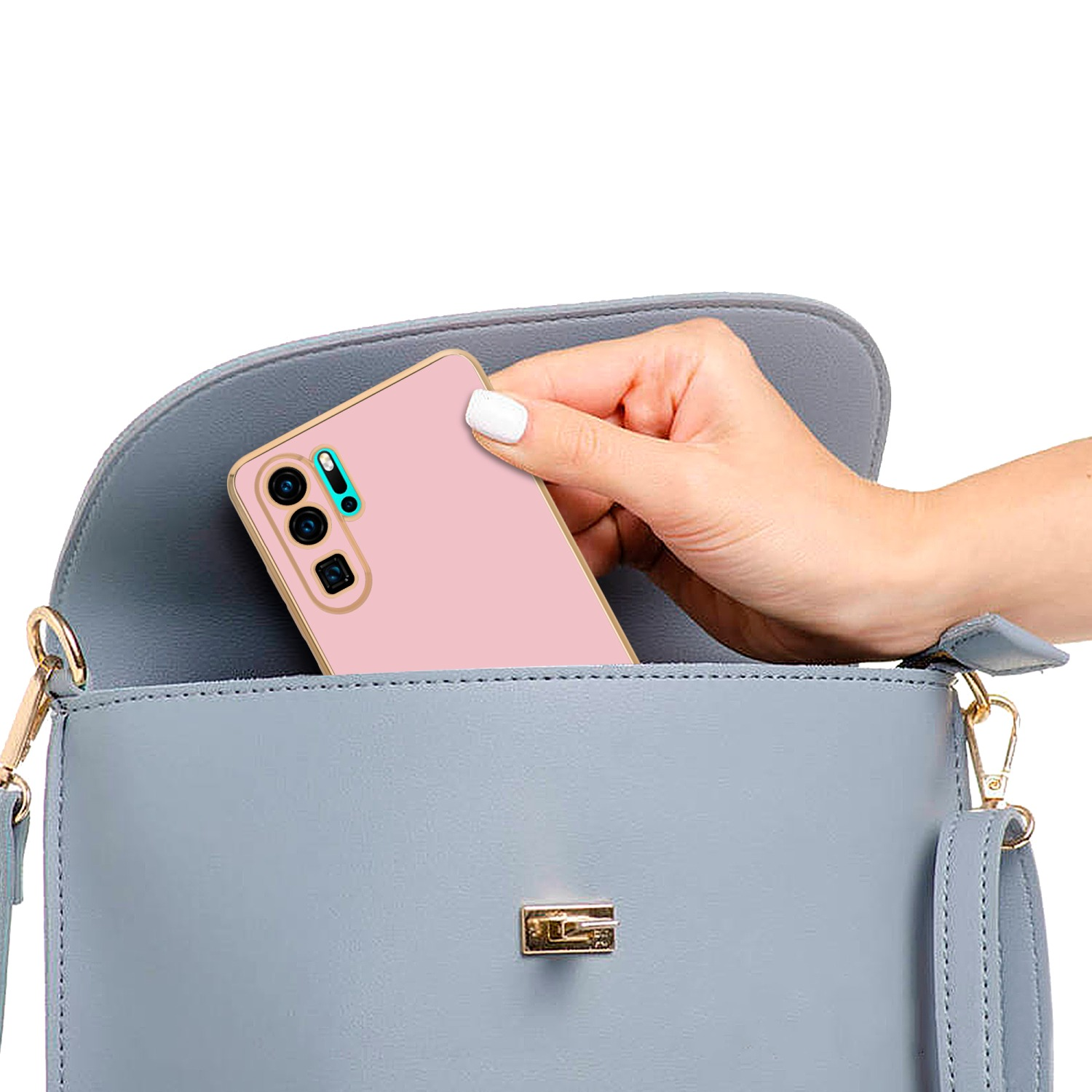 Eine Hand hält ein rosa Telefon in einer blauen Handtasche. Das Telefon hat eine rosa Hülle.