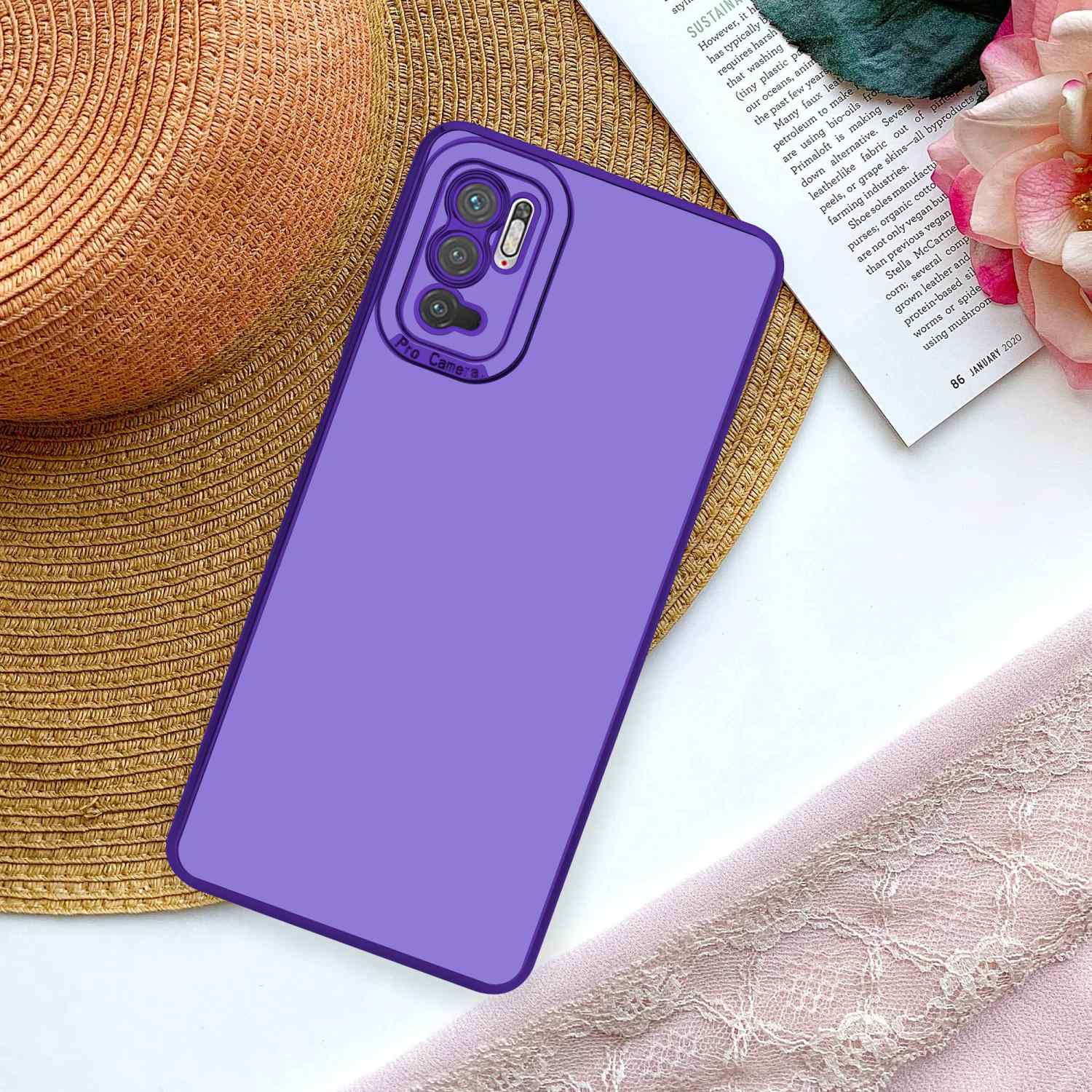 Lila Telefon mit Hülle auf einem Tisch. Hintergrund mit Hut, Buch und Blumen.