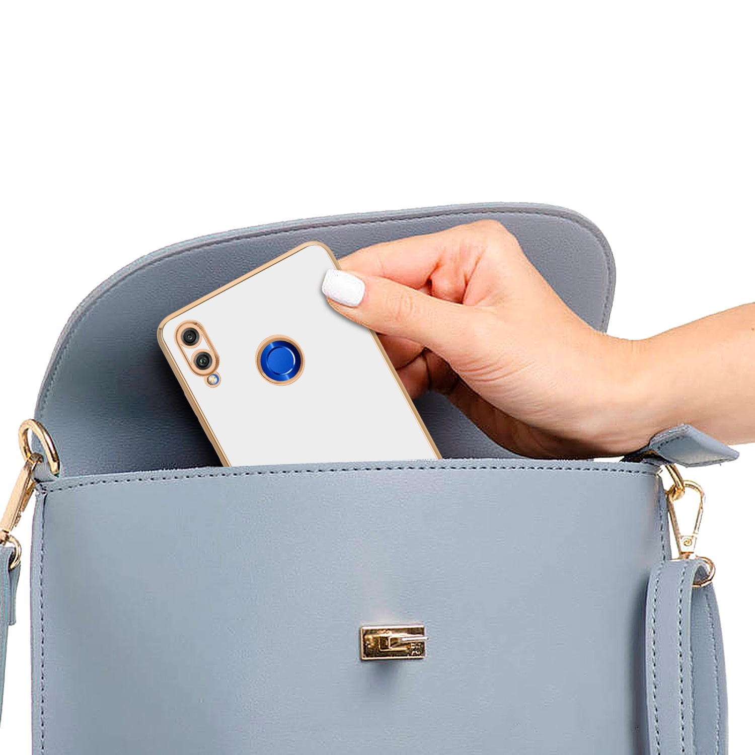 Hand hält Telefon in hellblauer Handtasche. Goldakzente. Telefon ist weiß mit goldfarbenem Zierrat.