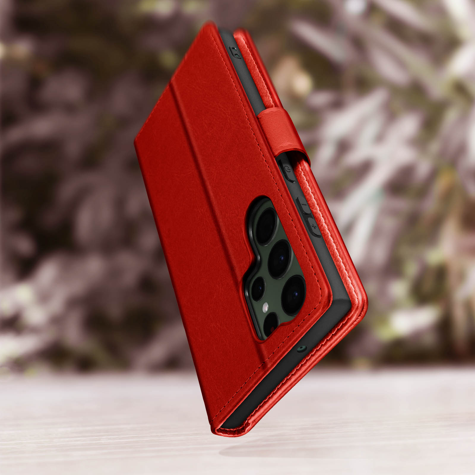 Een rode telefoonhoes met een telefoon erin. De hoes ligt op een houten oppervlak. Vage achtergrond.