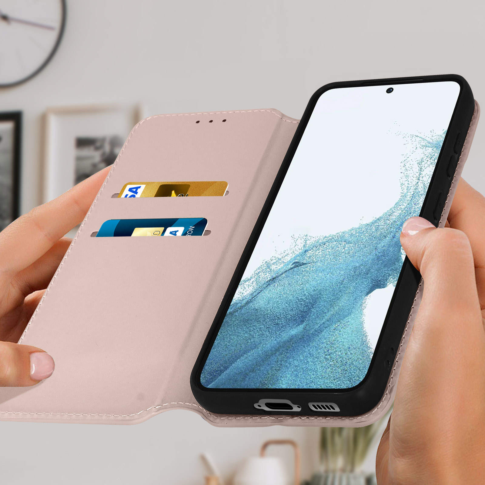 Personne tenant une coque rose, montrant un téléphone avec un écran bleu. Cartes de crédit visibles.