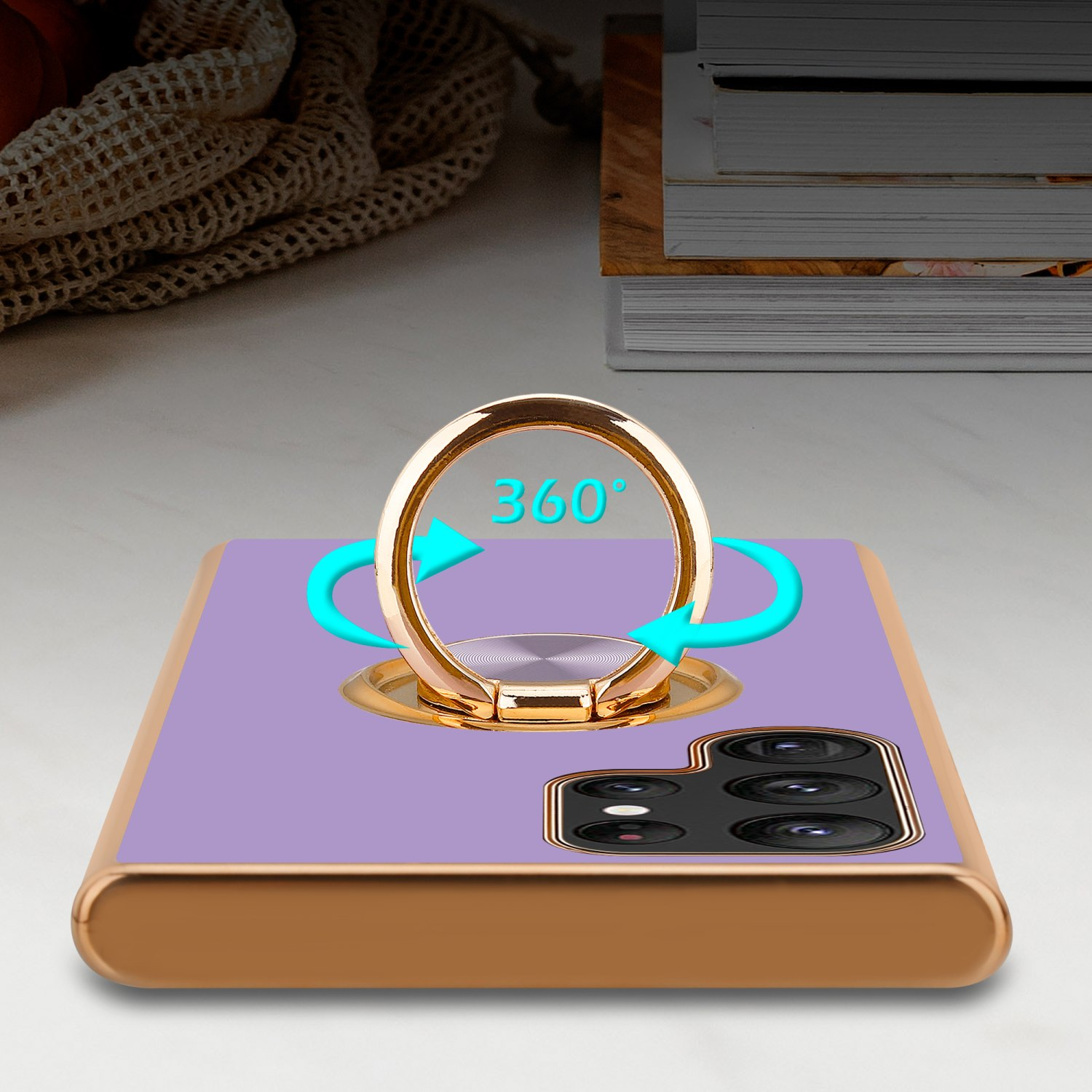 Custodia viola con bordo dorato e supporto ad anello. Frecce indicano rotazione a 360 gradi su una scrivania.