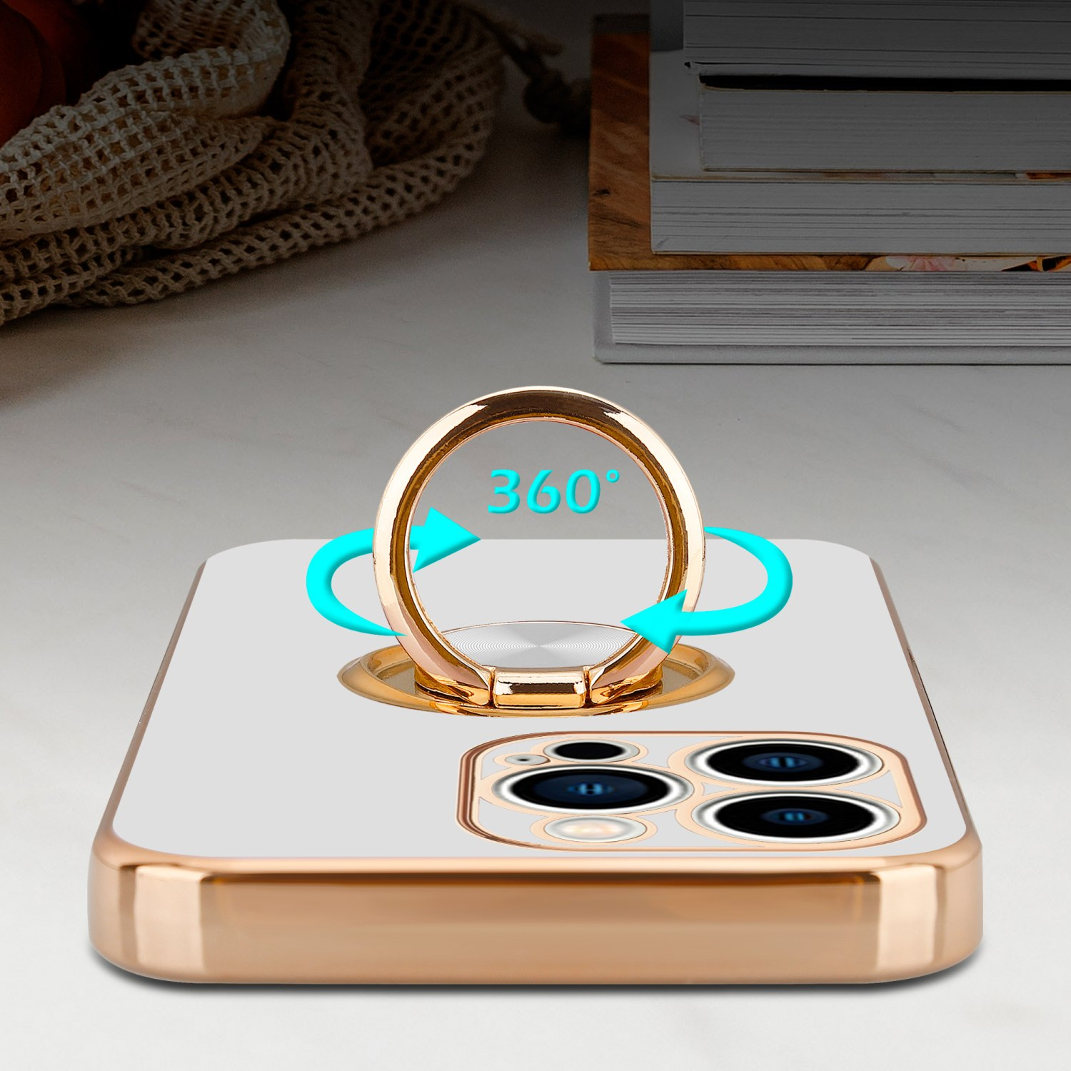 Weißes Handyhülle mit goldenem Ringhalter. Pfeile um den Ring. Tischhintergrund.