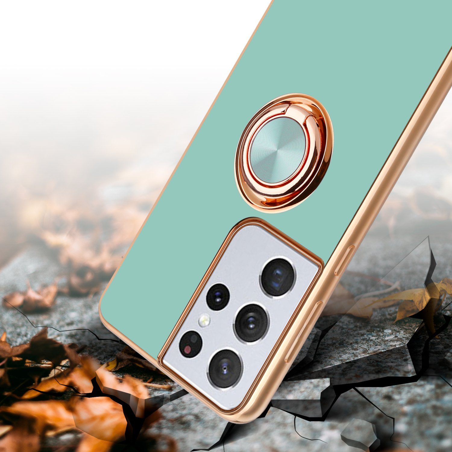 Custodia verde e telefono. Anello d'oro. La custodia ha dettagli della fotocamera. Sfondo grigio e marrone.