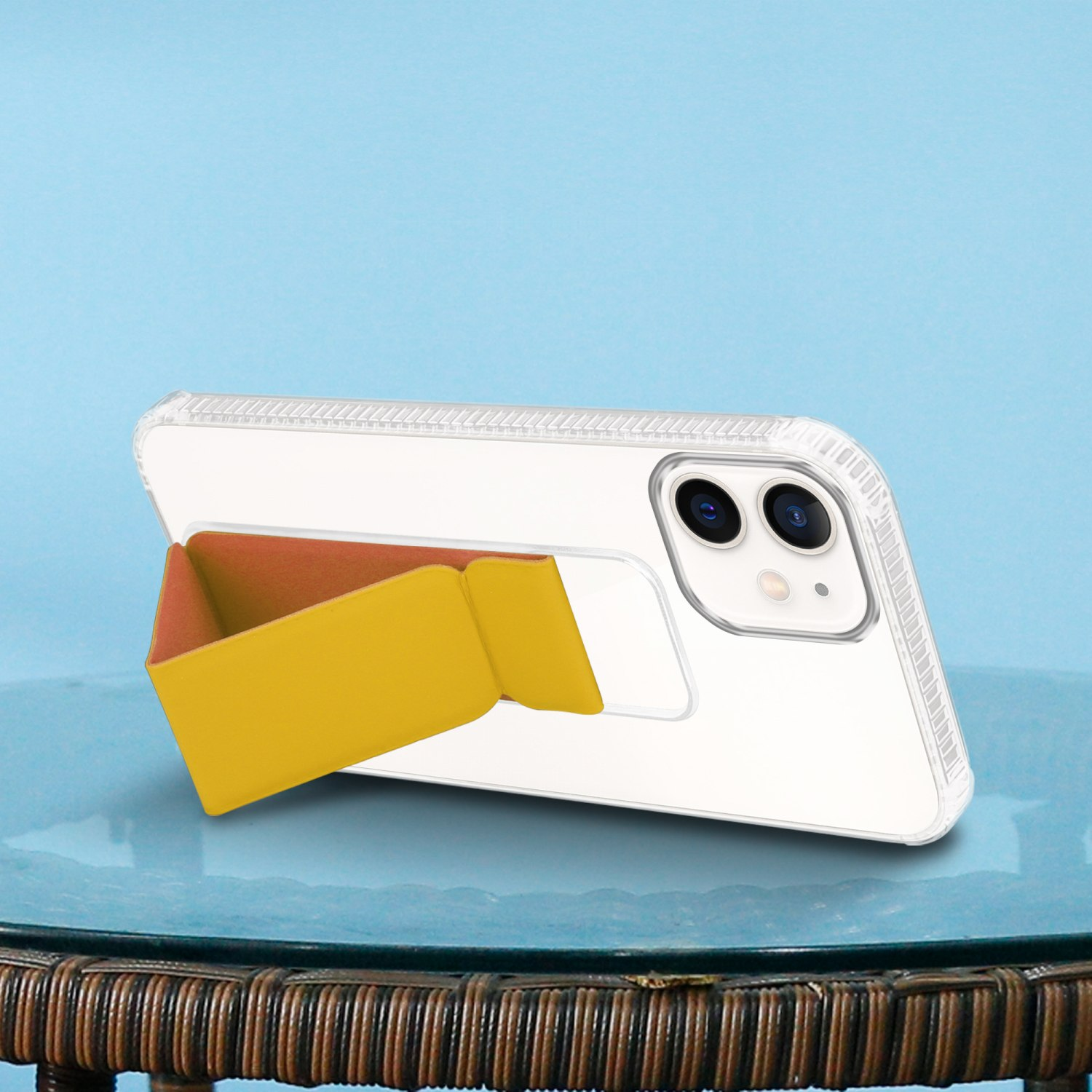 Ein weißes Telefon mit gelbem Ständer. Das Telefon steht auf einem Glastisch vor blauem Hintergrund.