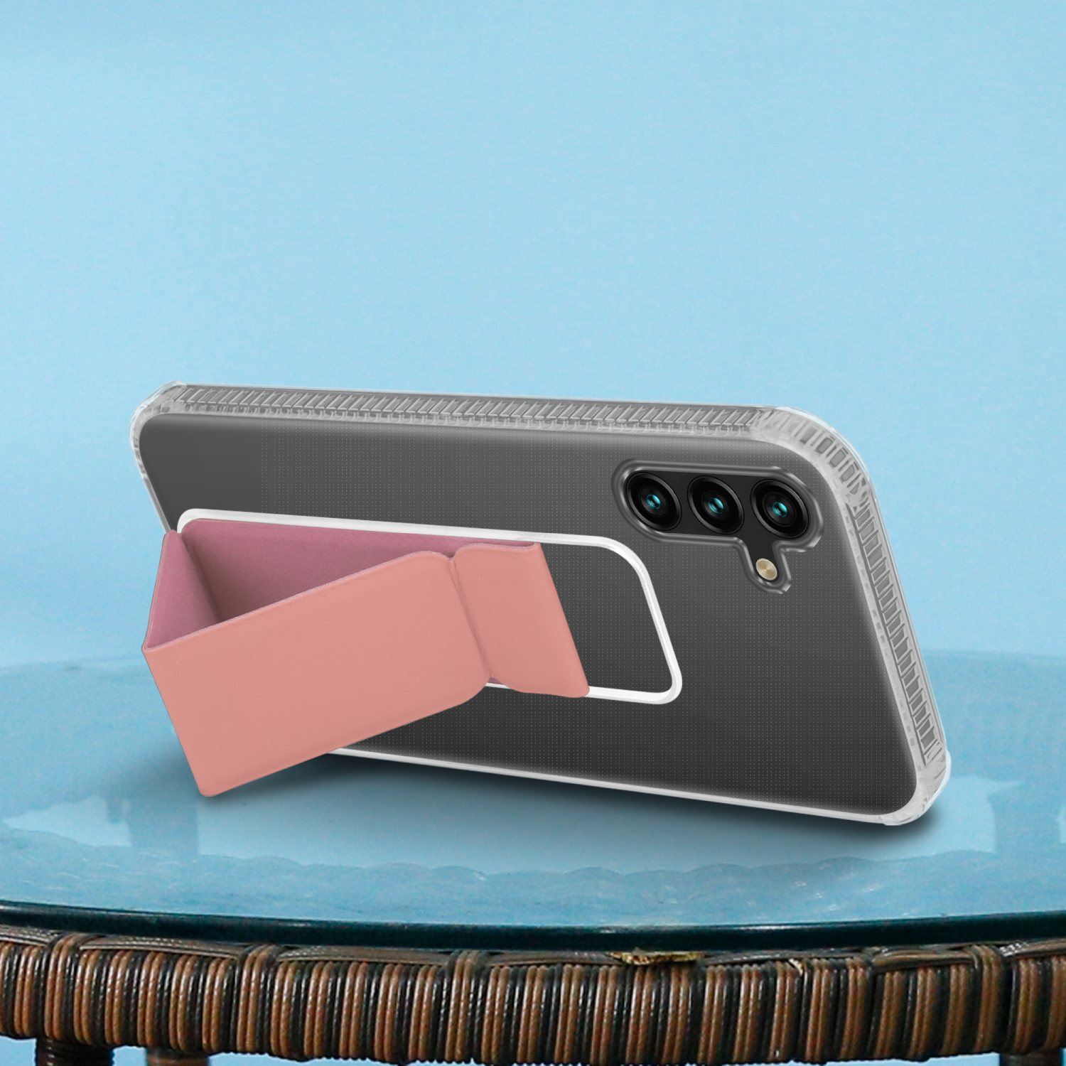 Ein Telefon in einer durchsichtigen Hülle mit pinkfarbenem Ständer steht vor blauem Hintergrund.