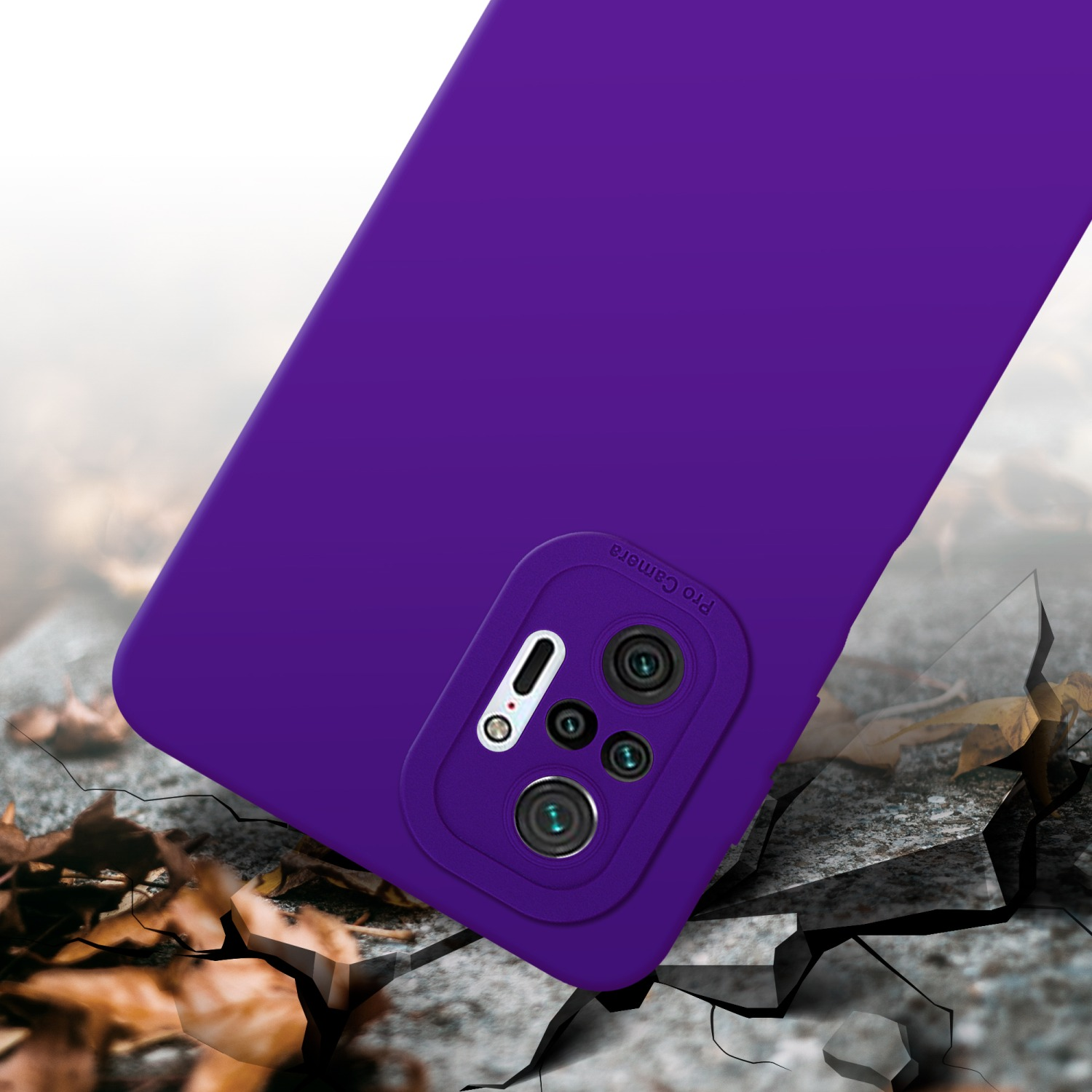 Coque de téléphone violette avec découpe caméra. Le fond montre du béton fissuré et des feuilles.