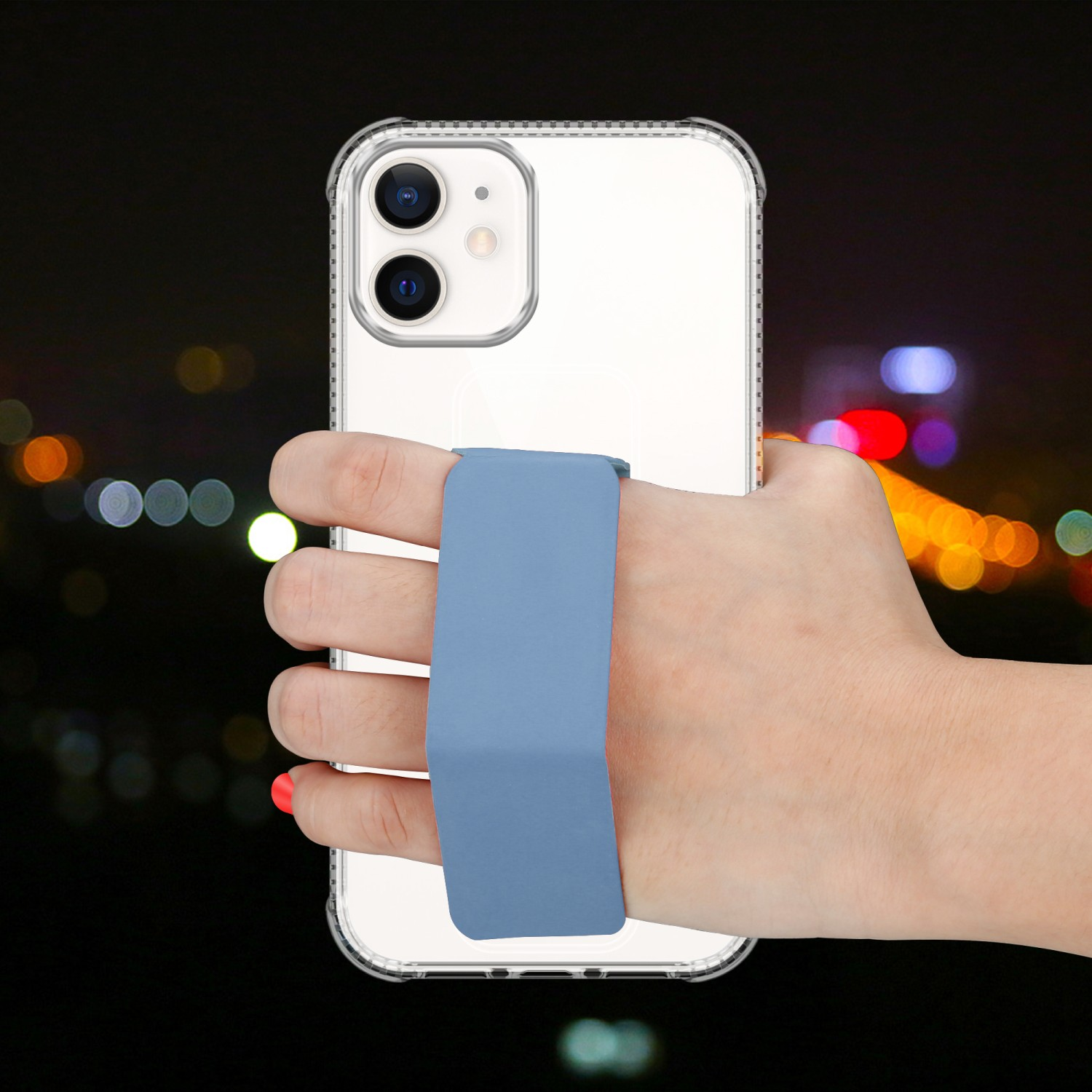 Hand hält transparente Handyhülle mit blauem Riemen vor verschwommenem Nacht-Hintergrund.