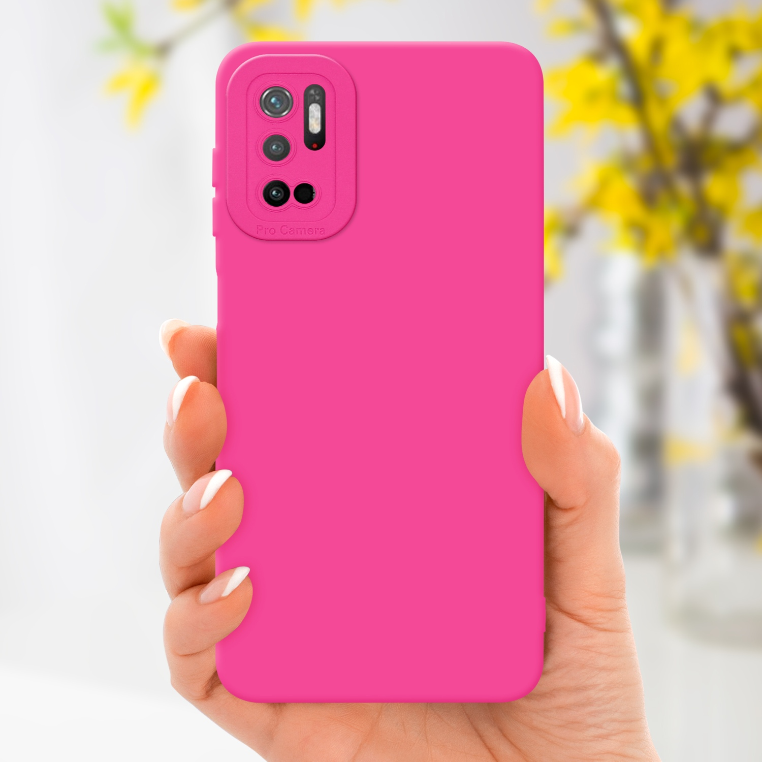 Una mano tiene una custodia rosa. Fiori gialli sullo sfondo sfocato. La custodia ha un rialzo per la fotocamera.