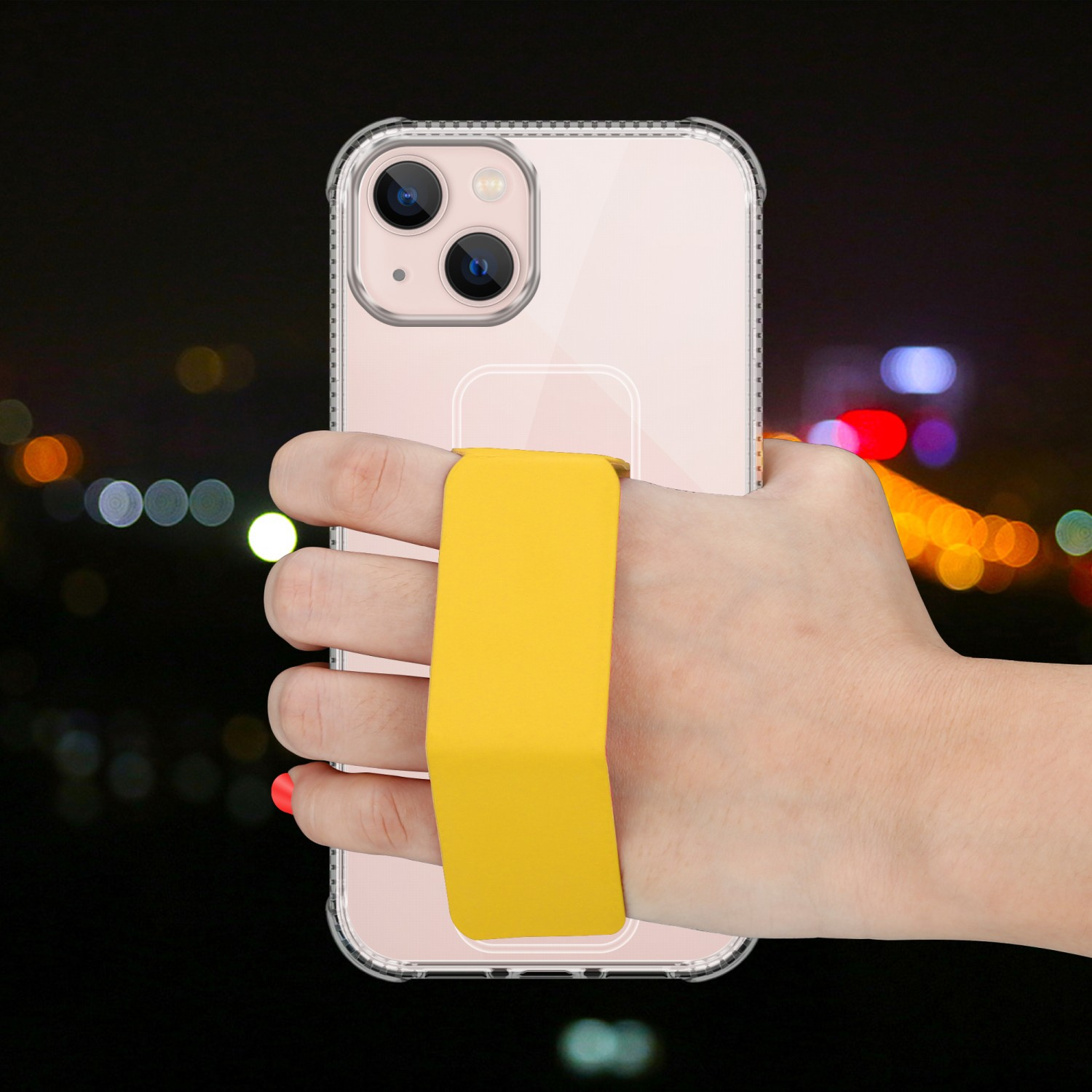 Eine Hand hält ein Telefon mit gelbem Riemen, vor verschwommenem Hintergrund.