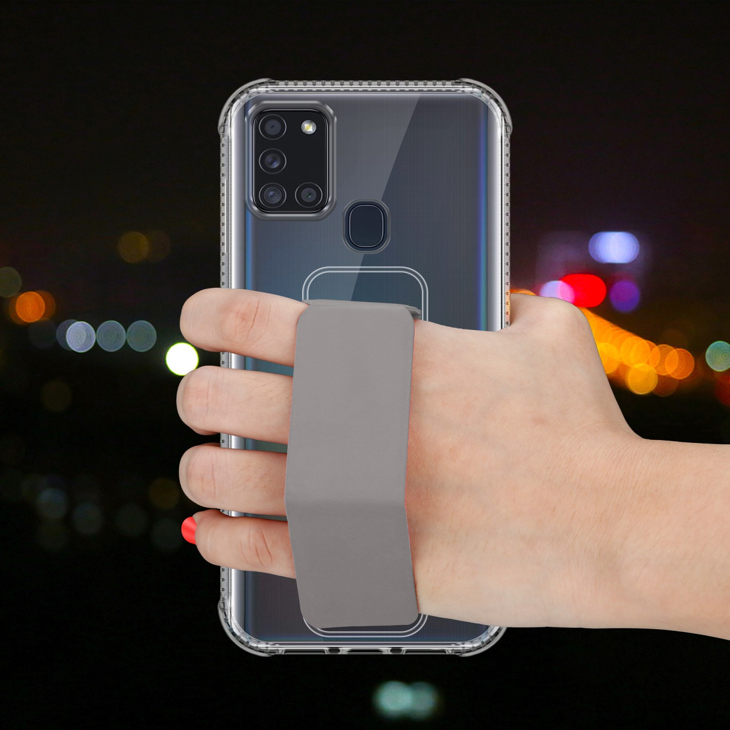Hand hält ein Telefon mit einer transparenten Hülle. Die Hülle hat eine Handschlaufe. Nacht Hintergrund unscharf.