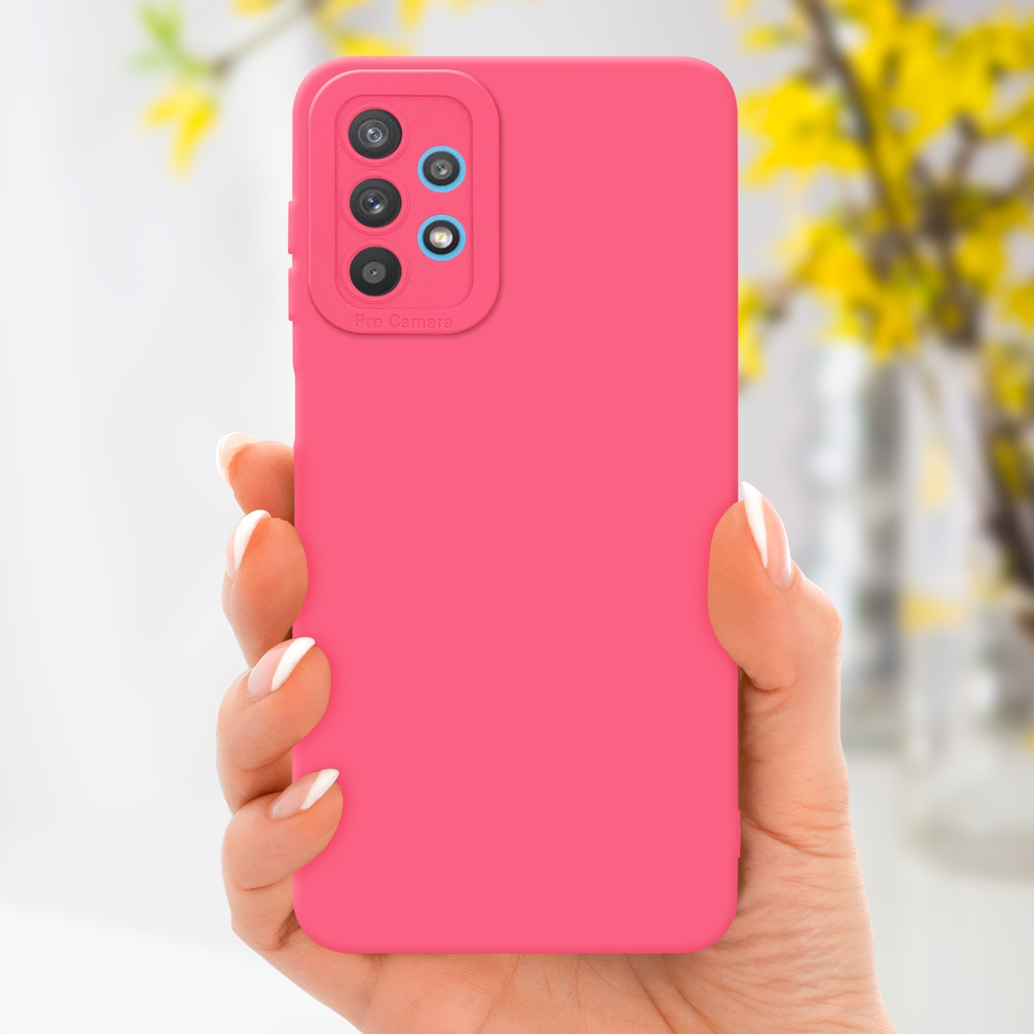 Custodia rosa per telefono tenuta in mano. Fiori gialli sfocati sullo sfondo.