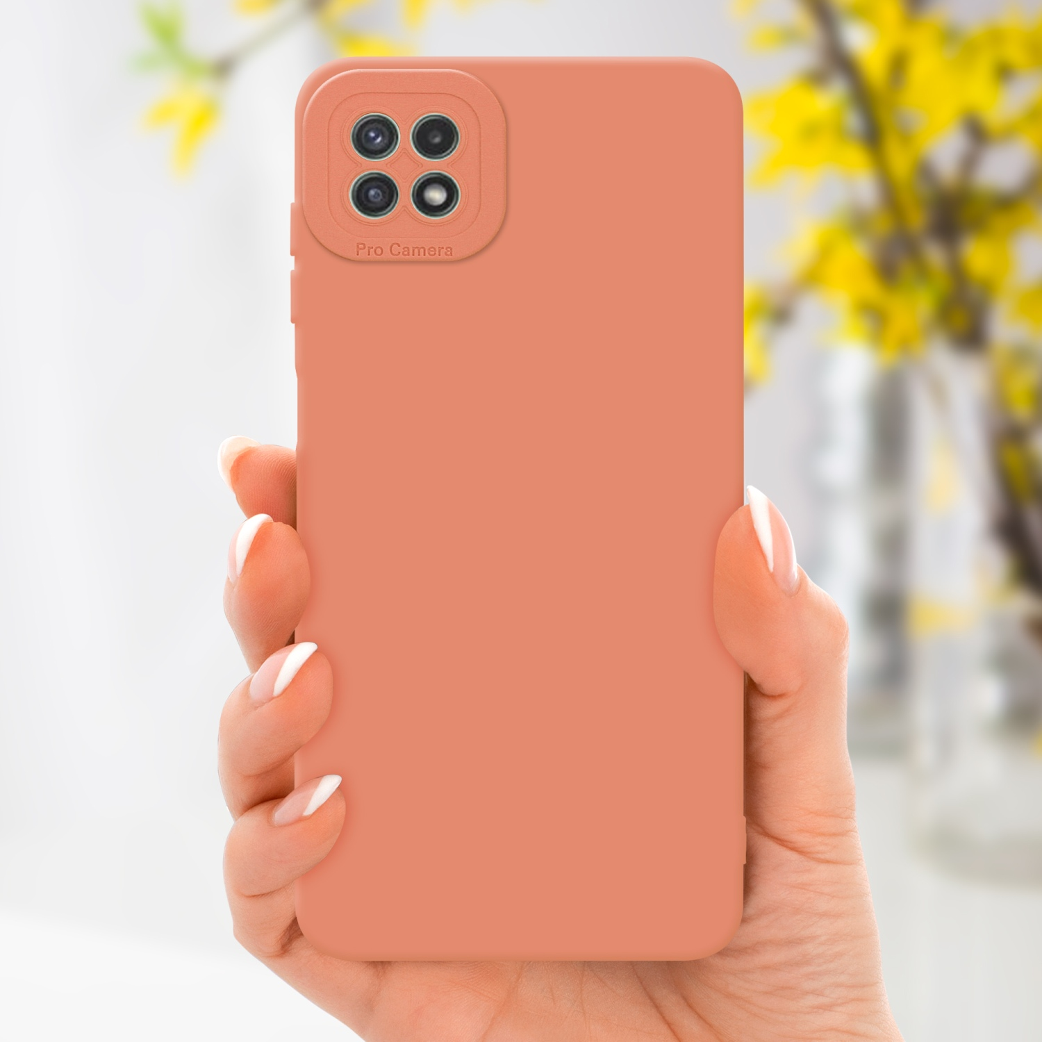 Main tenant une coque pêche. Fleurs jaunes en arrière-plan. Caméra mise au point.