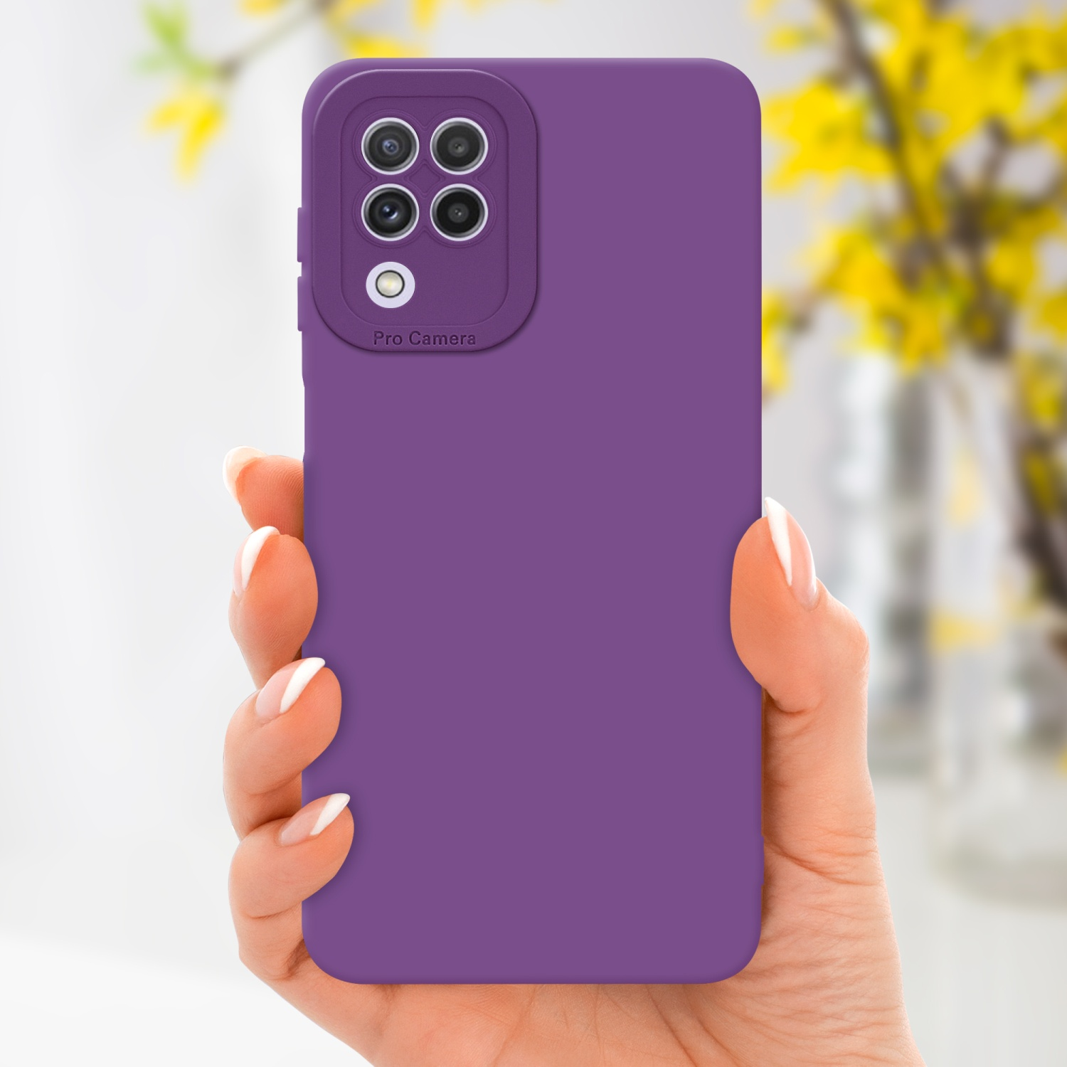 Main tenant une coque de téléphone violette avec une caméra pro. Fleurs jaunes en arrière-plan.