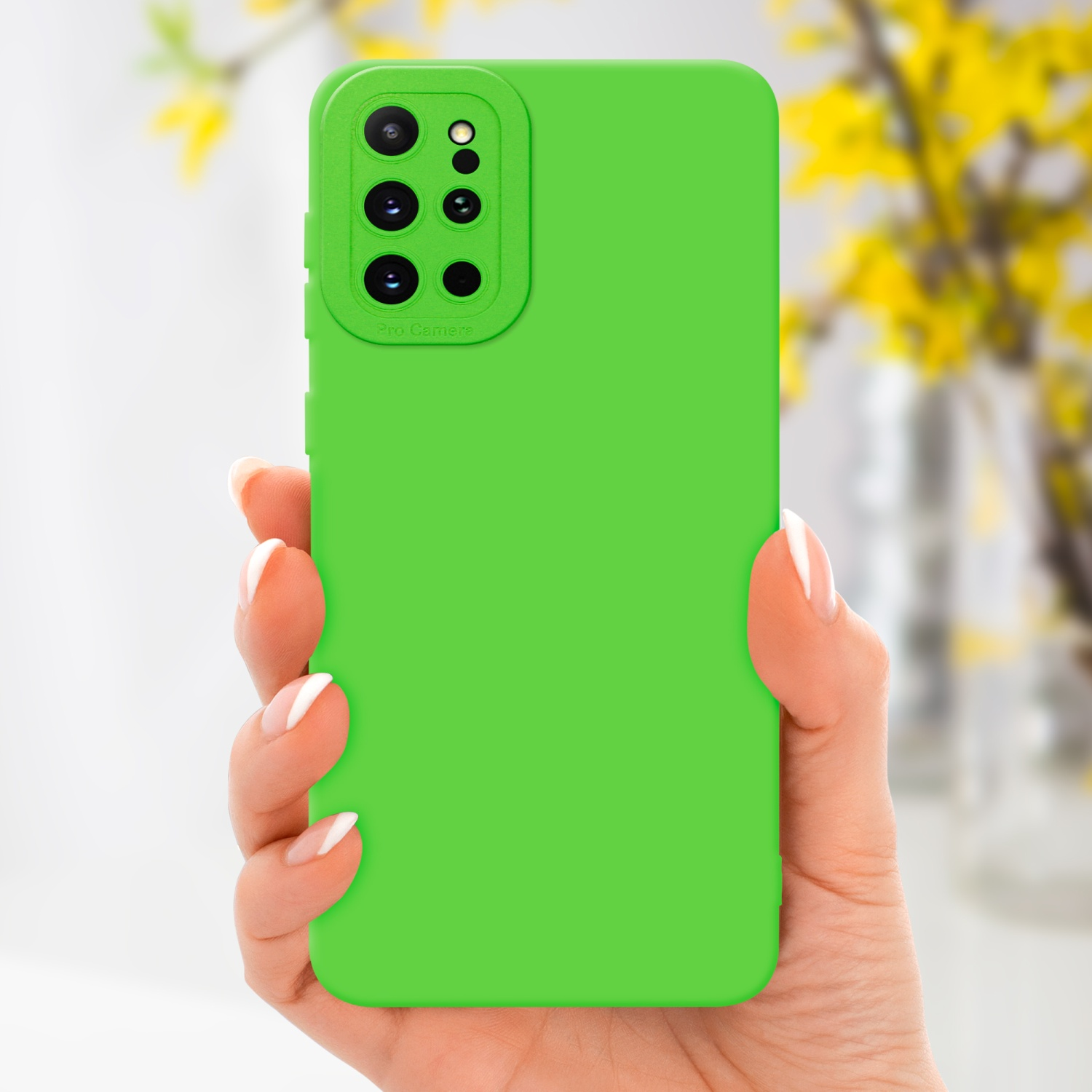 Mano che tiene una custodia verde per telefono. Fiori gialli sullo sfondo.