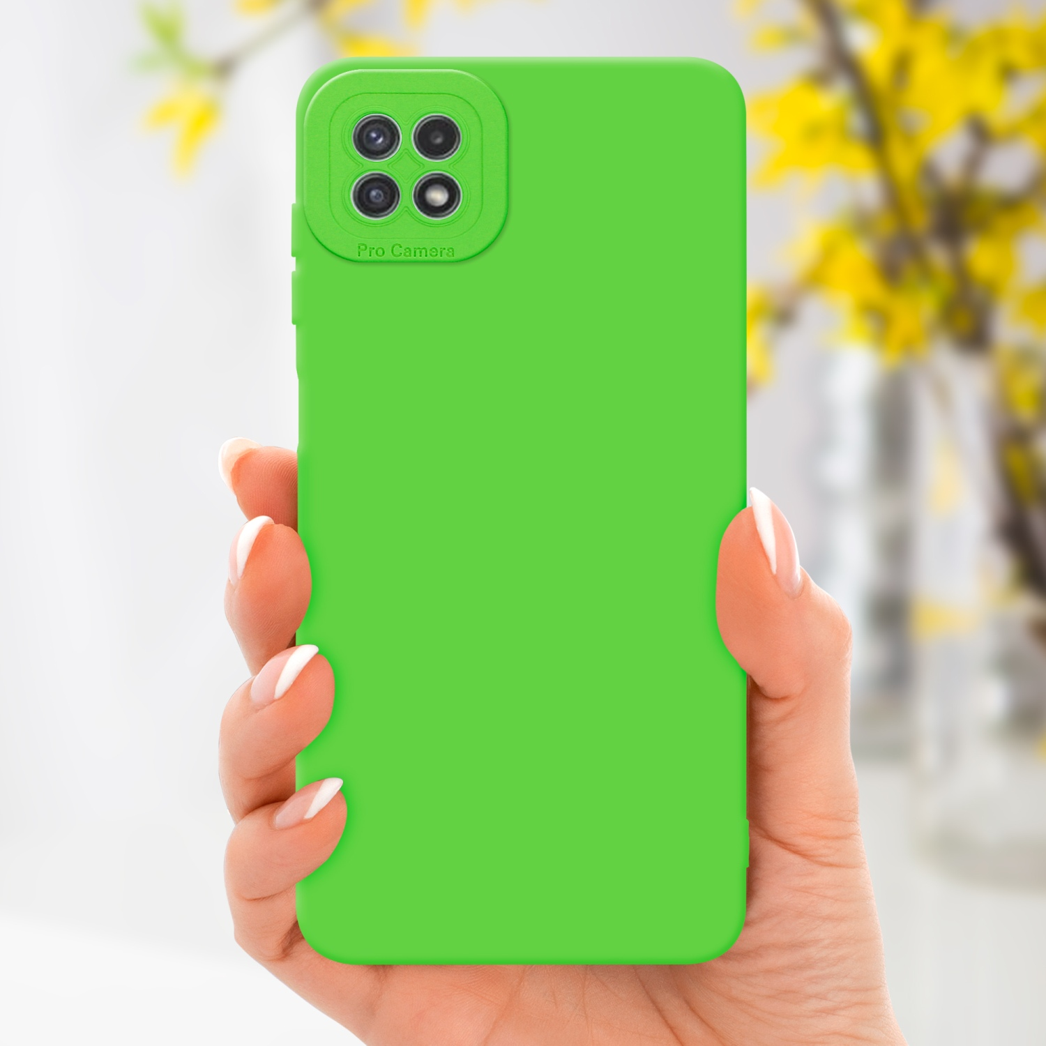 Main tenant une coque de téléphone verte avec une découpe pour la caméra.